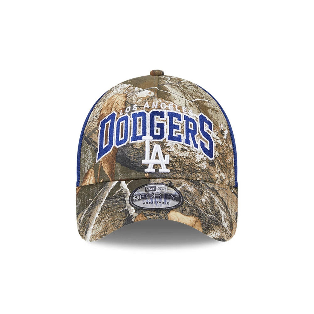 LA Dodgers MLB Realtree Camo Dark Blue New Era 9FORTY A-Frame Trucker Adjustable Cap, front view showing raised blue Dodgers logo and white LA letters on the camouflage crown, with 9FORTY size sticker on the curved visor.