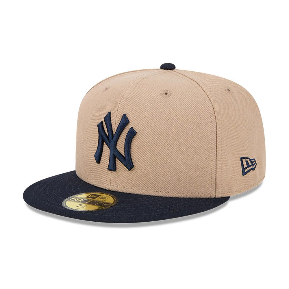 New York Yankees MLB Evergreen Light Beige New Era 59FIFTY Fitted Cap, three-quarter view showing the raised navy NY logo on the front panel, a navy visor with a gold 59FIFTY size sticker, and a New Era flag logo on the left side.
