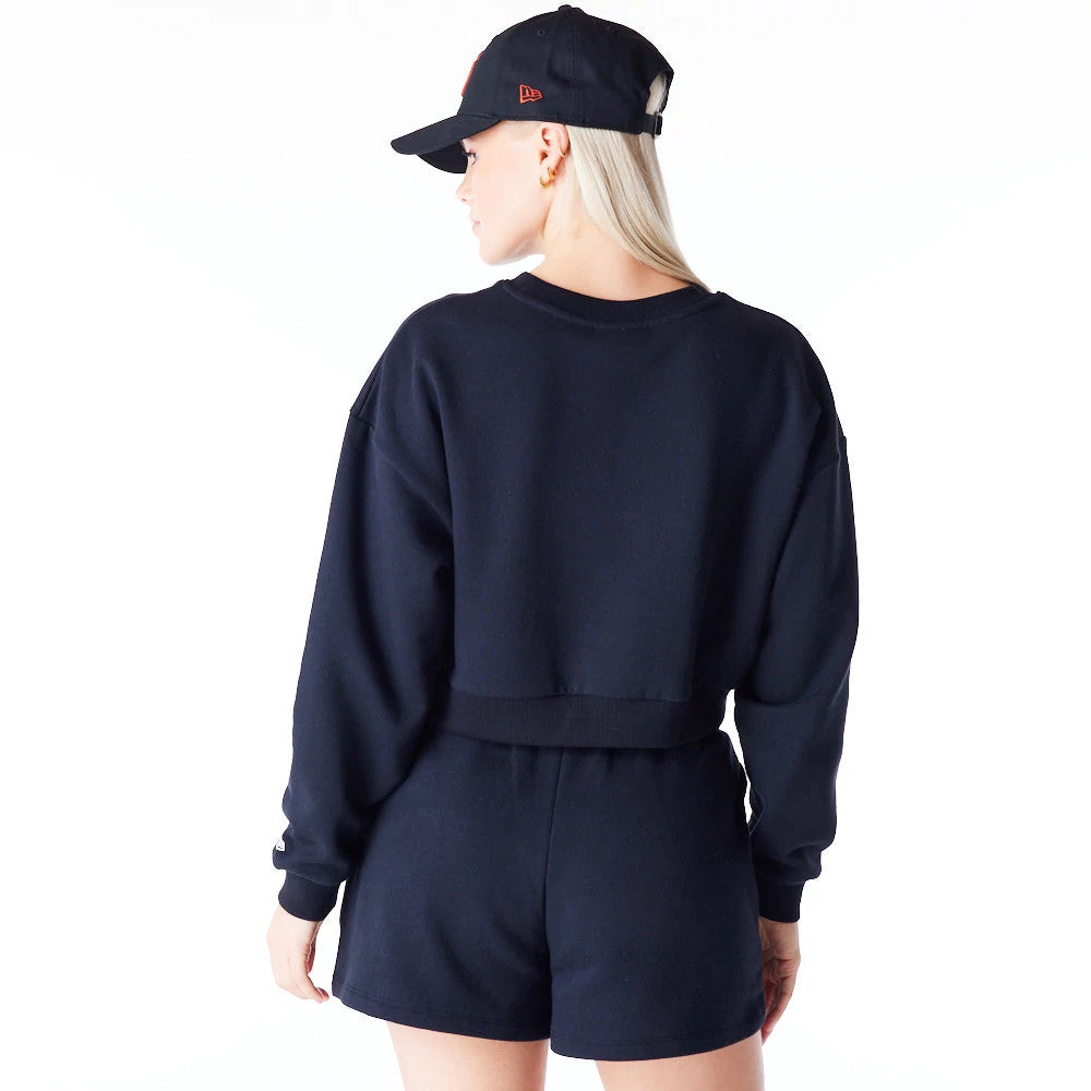 New Era New York Yankees Womens MLB League Essential Black Crop Crew Neck Sweatshirt, back view on a model wearing matching shorts and a black cap, showing the cropped hem and relaxed fit of the sweatshirt.