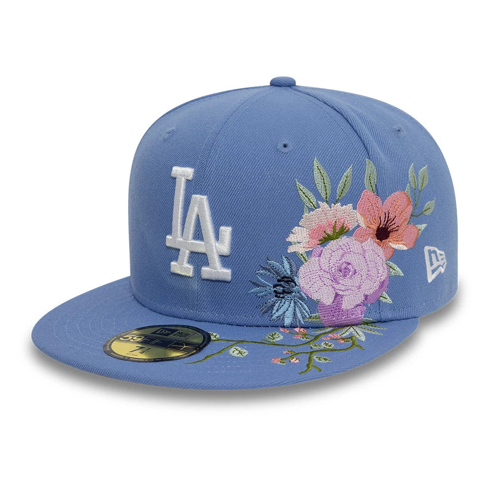 LA Dodgers MLB Floral Blue New Era 59FIFTY Fitted Cap, three-quarter view showing the white raised LA logo on the front panel, multicolour floral embroidery on the right front panels, and the gold 59FIFTY size sticker on the flat blue visor.