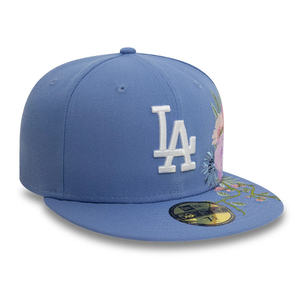 LA Dodgers MLB Floral Blue New Era 59FIFTY Fitted Cap, three-quarter view showing white LA logo raised embroidery on the front panel, with colourful floral embroidery on the right side and gold 59FIFTY size sticker on the blue visor.