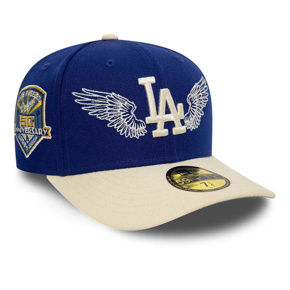 LA Dodgers MLB Team Wings Navy New Era 59FIFTY Fitted Cap, three-quarter view showing the white embroidered LA and wings logo on the front panel, gold 59FIFTY size sticker on the beige visor, and a 50th anniversary patch on the left side.