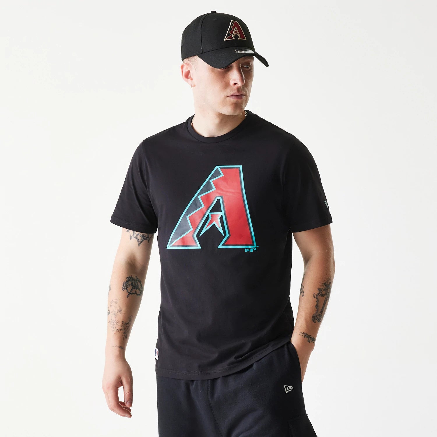New Era Arizona Diamondbacks MLB Regular Black T-Shirt, on-model view showing the front with a large red and teal Arizona Diamondbacks logo, paired with a black cap featuring a matching raised logo on the front.