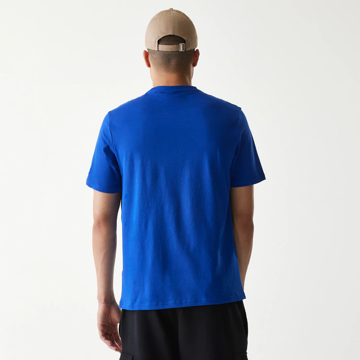 New Era Kansas City Royals MLB Regular Blue T-Shirt, rear view showing the plain blue fabric with short sleeves on a model wearing a beige cap, the back panel extends smoothly without any logos or embellishments.