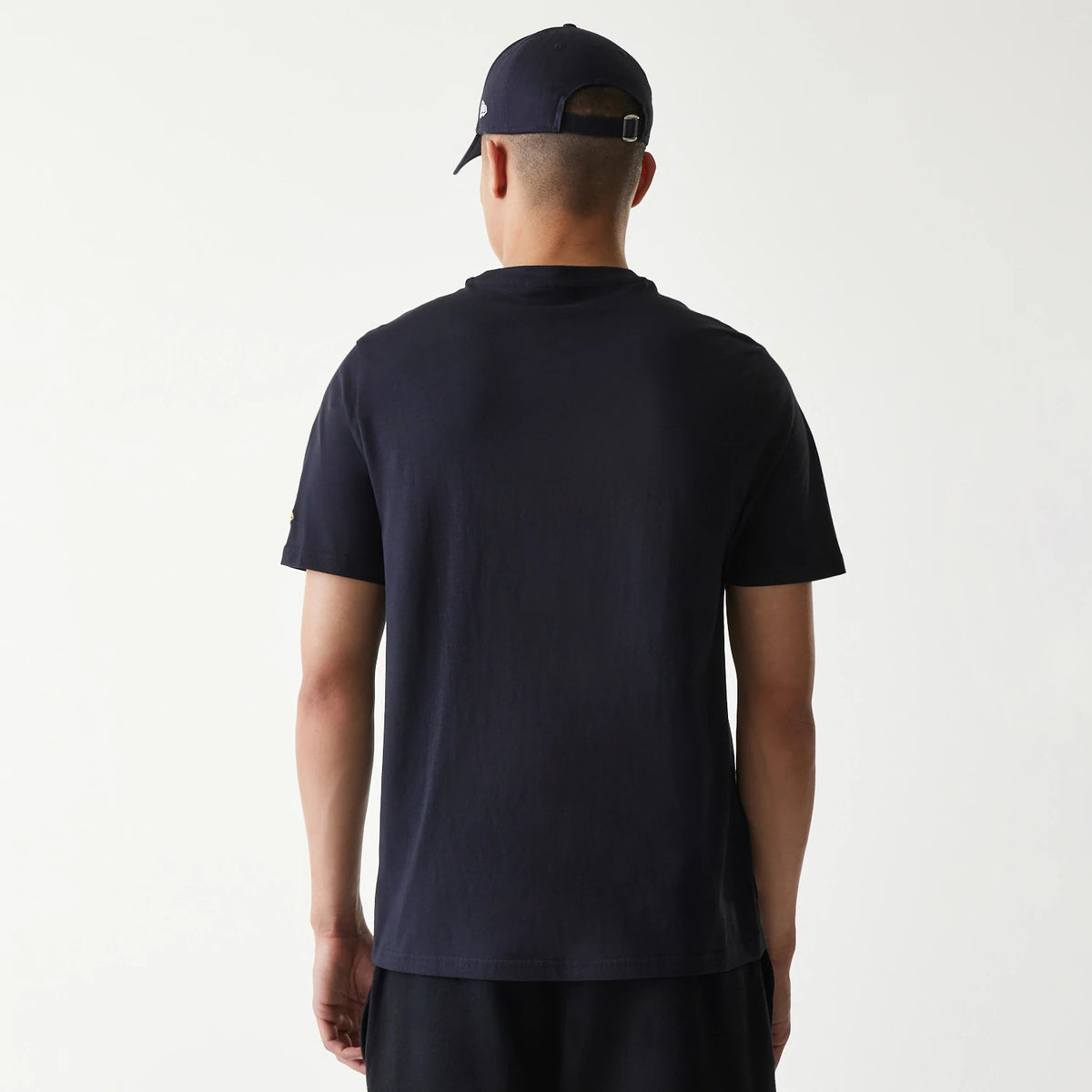 New Era San Diego Padres MLB Regular Navy T-Shirt, rear view showing the plain navy back with short sleeves, worn by a model wearing a navy cap featuring a small raised logo on the side.