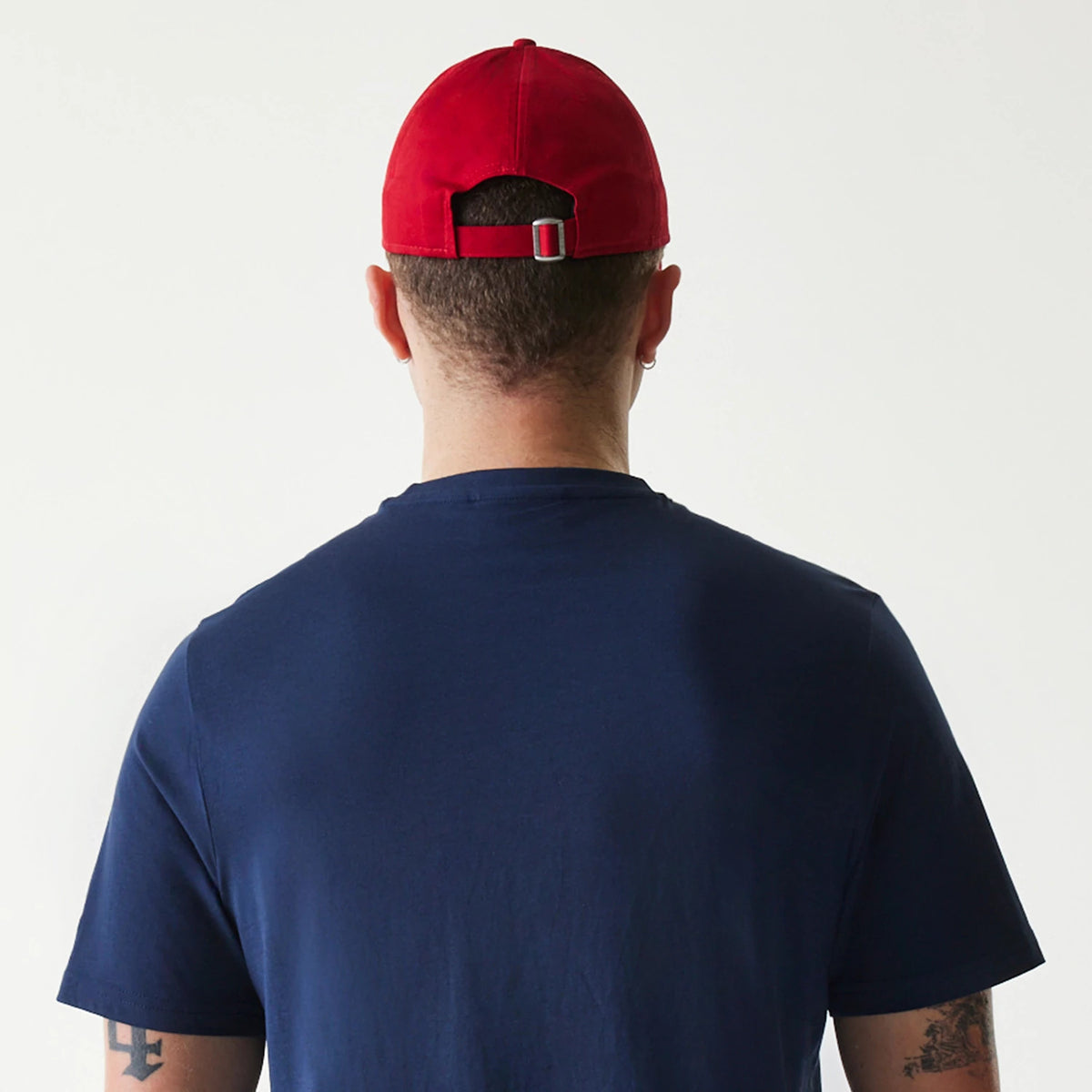 New Era Texas Rangers MLB Regular Dark Blue T-Shirt, rear view showing a man wearing the dark blue T-shirt with a red cap, featuring an adjustable strap at the back, the cap positioned centrally on the head and T-shirt fitting comfortably.