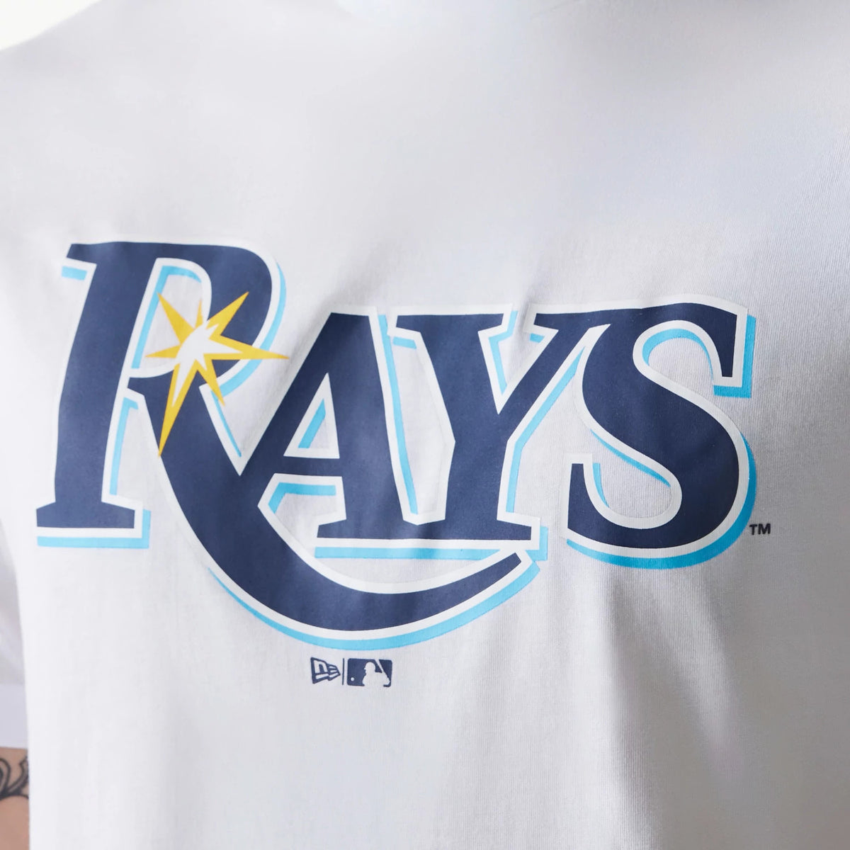New Era Tampa Bay Rays MLB Regular White T-Shirt, front view showing the large navy and light blue Rays graphic across the chest with a yellow star on the R, and an embossed New Era logo below the graphic.