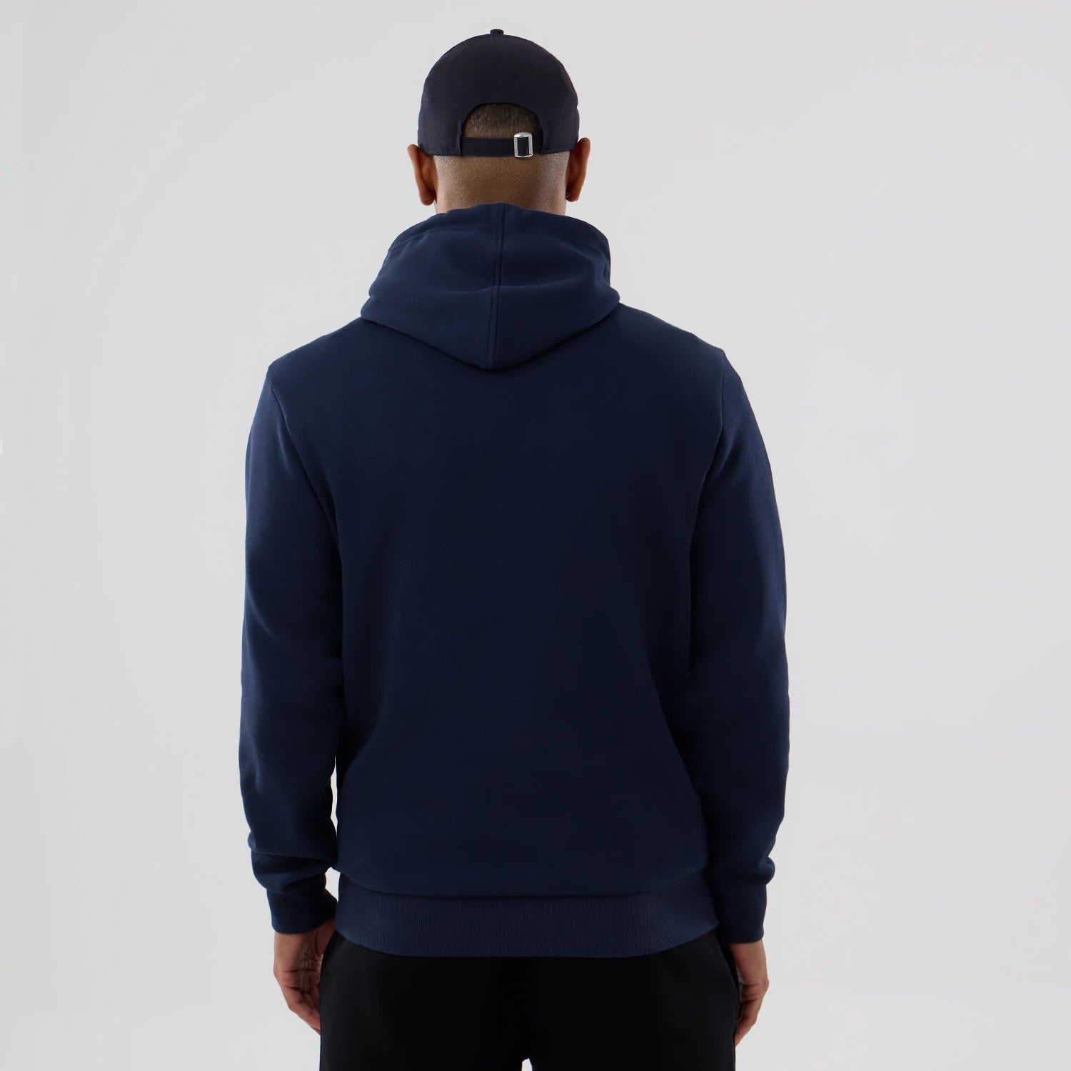 New Era Houston Astros MLB Dark Blue Pullover Hoodie, on-model view from the back showing the dark blue hoodie with a sewn hem at the waist and cuffs, a man wearing a dark blue cap with debossed logo and adjustable strap at the back.