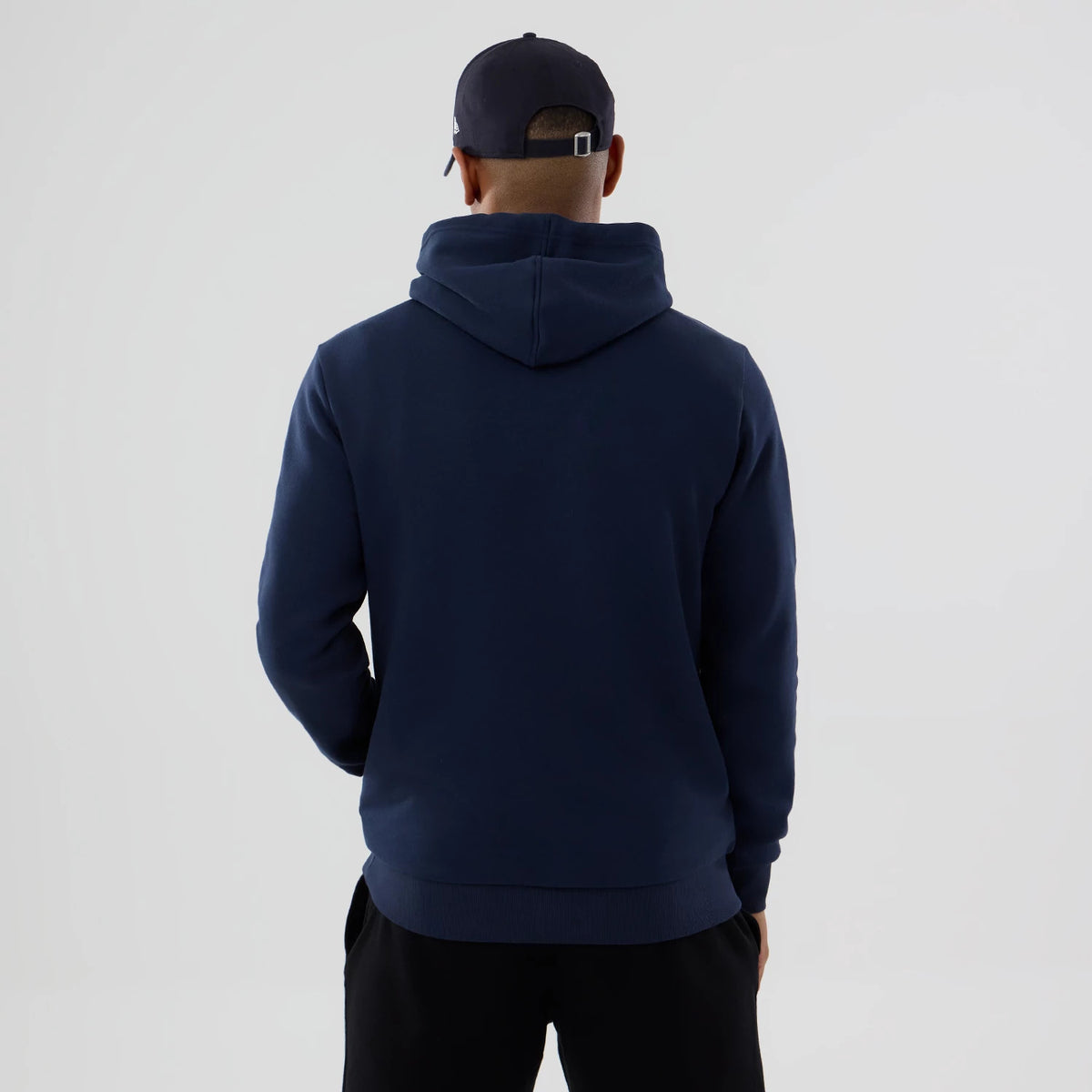New Era LA Angels MLB Dark Blue Pullover Hoodie, rear view showing the dark blue fabric with a relaxed hood resting on the back and a New Era embossed logo on a dark blue cap worn by the model.