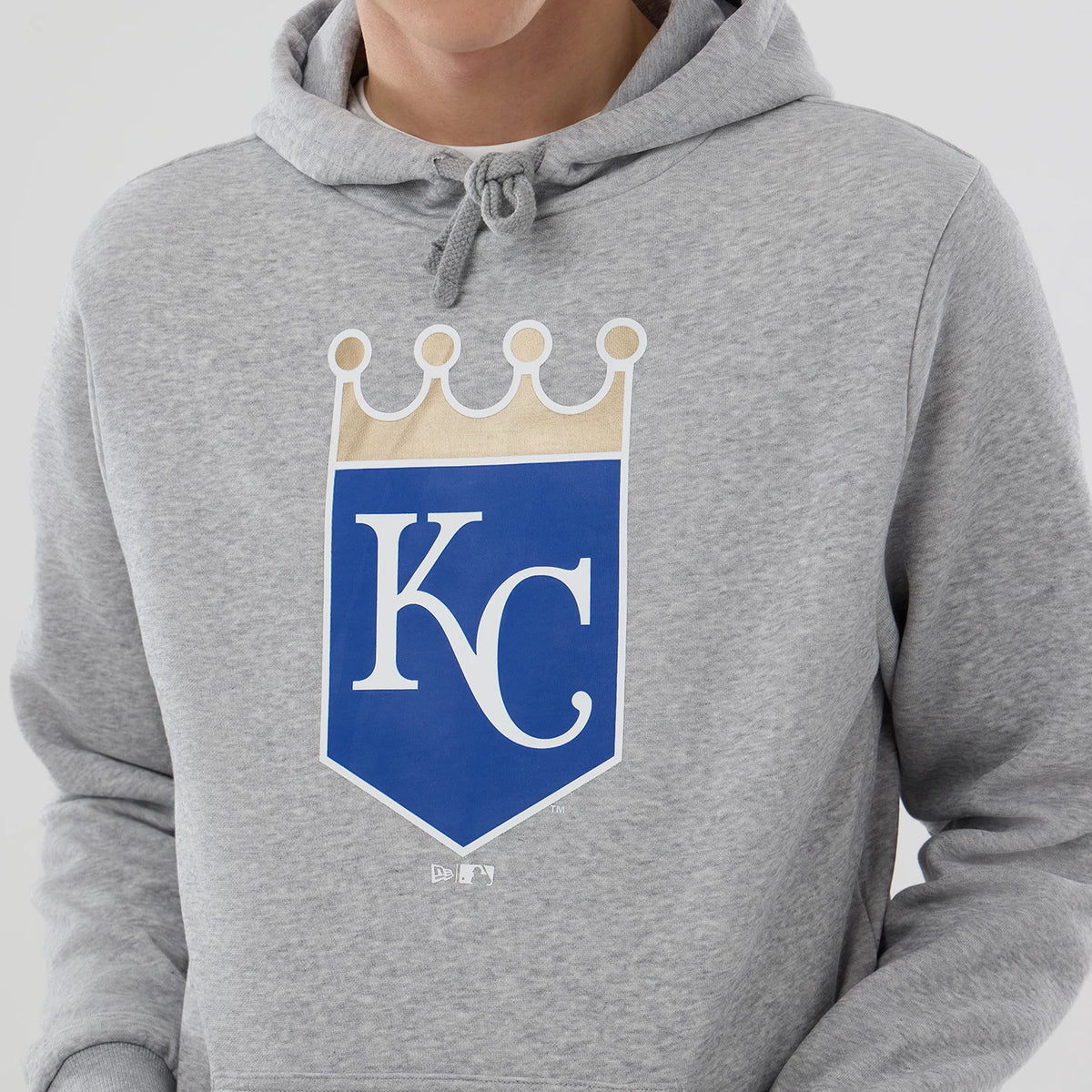 New Era Kansas City Royals MLB Grey Pullover Hoodie, front view showing a large blue and beige Kansas City Royals crest on the chest, with drawstrings on the hood and a small white embossed New Era logo near the bottom.