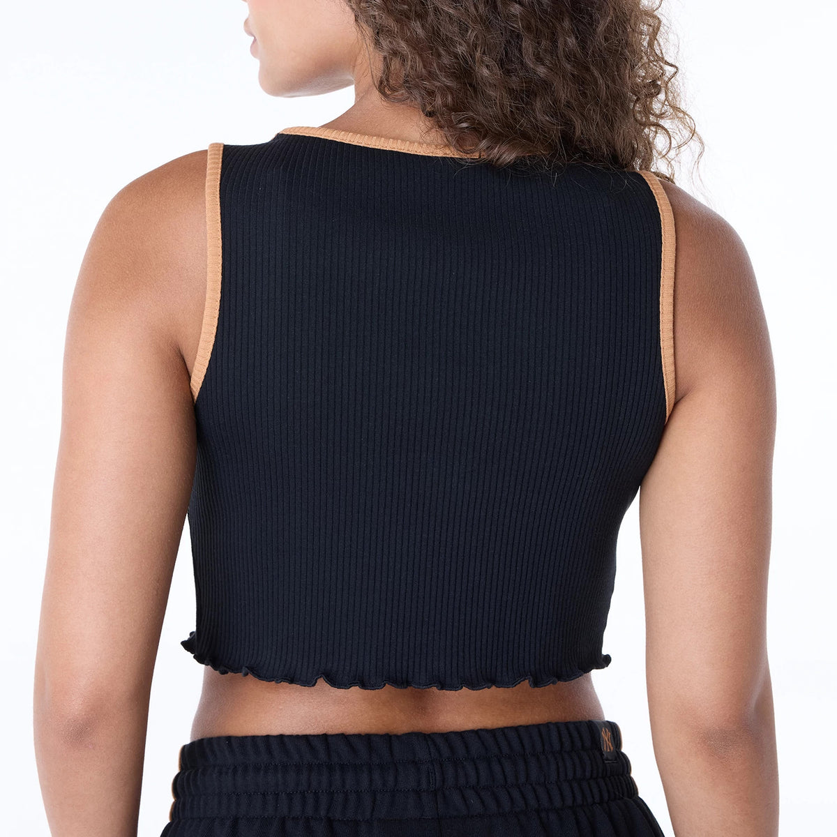 New Era New York Yankees Womens MLB Floral Black Vest, back view on a model showing ribbed black fabric with tan trim on shoulders and neckline, paired with matching black shorts featuring an embroidered NY logo on the waistband.