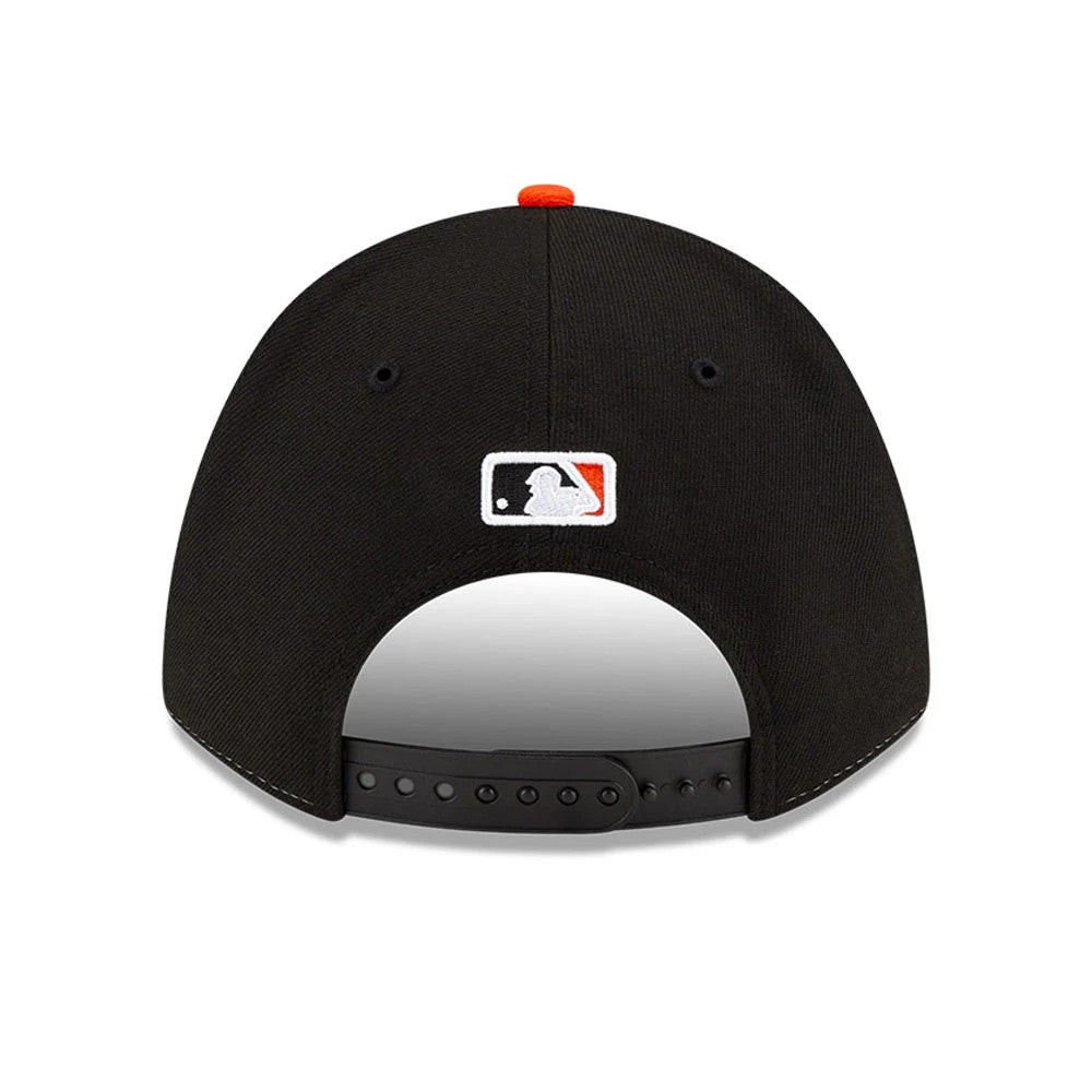 Baltimore Orioles MLB Player Replica White New Era 9FORTY M-Crown Adjustable Cap, rear view showing the white embroidered MLB Batterman logo at the centre of the black back panels, with an orange top button and adjustable snap closure.