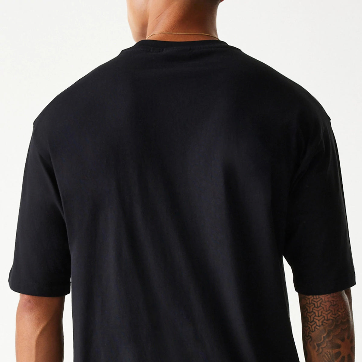 New Era Chicago Bulls NBA Team Graphic Black Oversized T-Shirt, rear view showing the plain black back panel reaching down to the elbows, with the fabric of the oversized cut creating a relaxed fit.