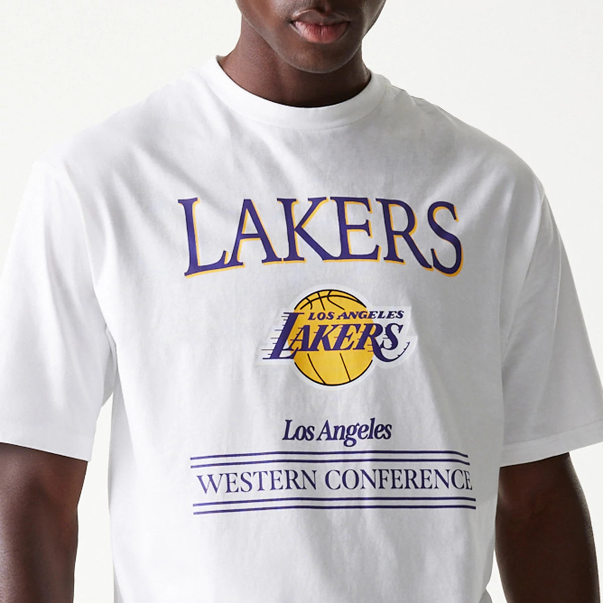New Era LA Lakers NBA Team Graphic White Oversized T-Shirt, front view showing a bold purple and gold LAKERS print with a basketball graphic, Los Angeles and WESTERN CONFERENCE text below, on a white T-shirt.