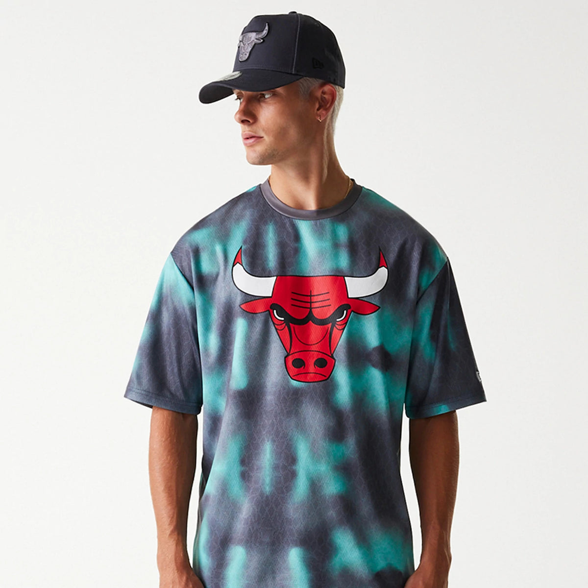 New Era Chicago Bulls NBA All Over Print Green Oversized T-Shirt, front view showing the Bulls logo in red and white prominently printed on a green and grey tie-dye pattern, with short sleeves and a round neckline.