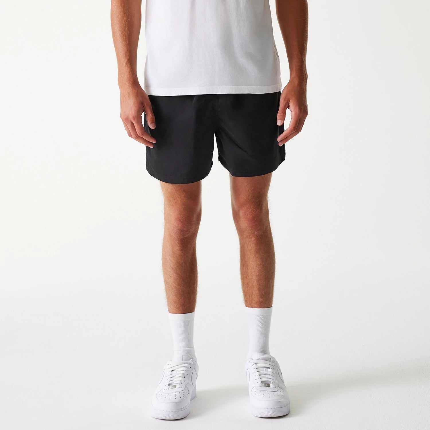 The Male model is wearing New Era Black Swim Shorts 1