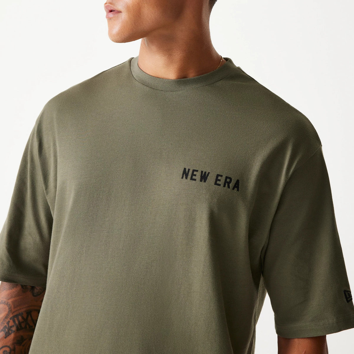 New Era Animal Graphic Green Oversized T-Shirt, front view showing the large green fabric with a raised black New Era logo on the chest and short sleeves with another raised logo on the left sleeve.