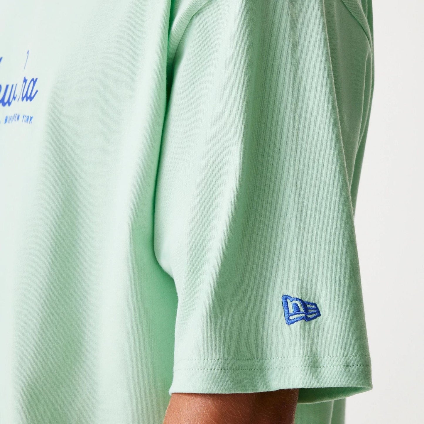 The Male model is wearing New Era Vacation Graphic Pastel Green Oversized T-Shirt 8