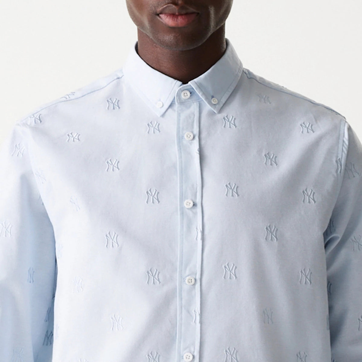 New Era New York Yankees MLB Monogram Pastel Blue Long Sleeve Shirt, front view showing the buttoned collar and embroidered NY logo pattern across the light blue fabric, with long sleeves and buttoned placket.