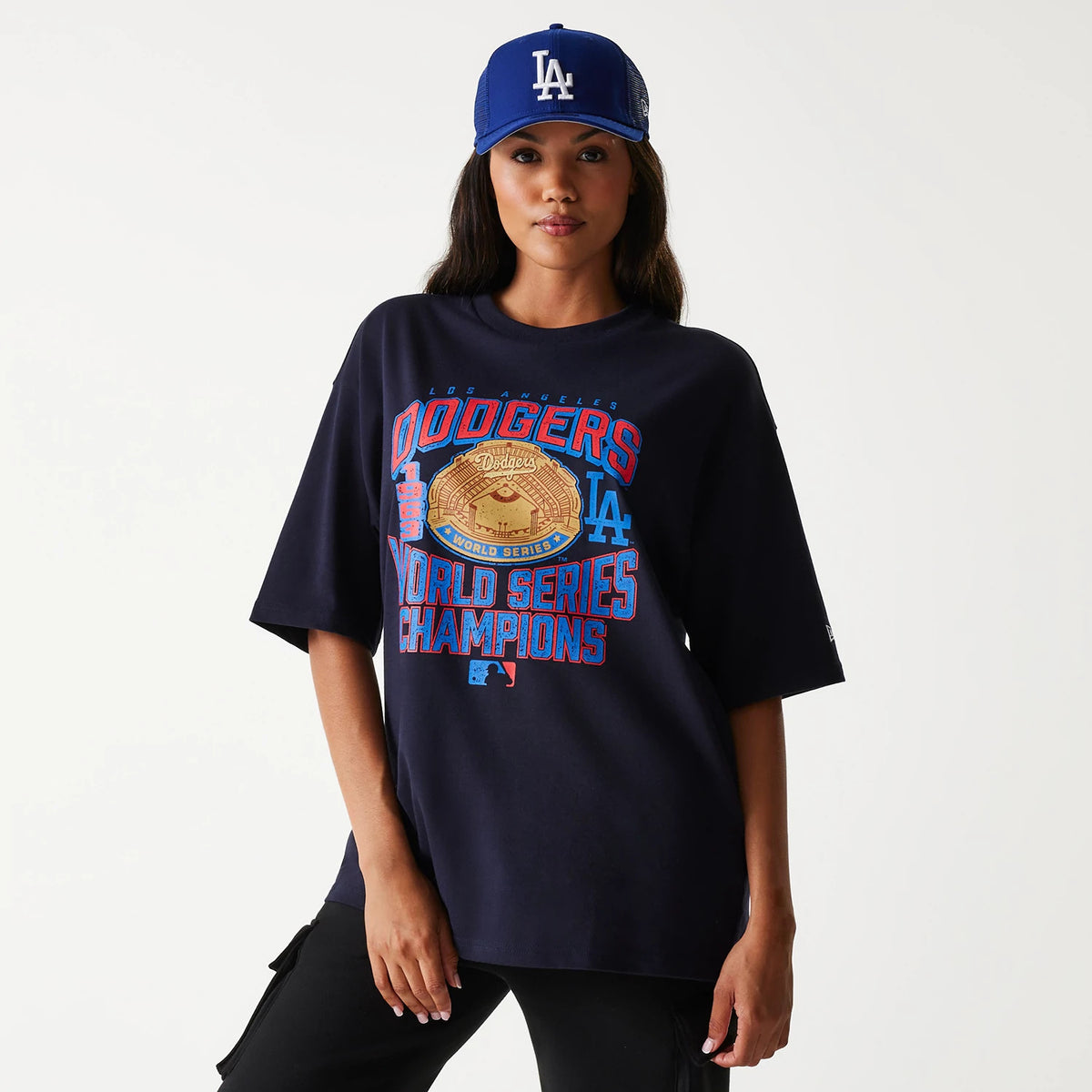 New Era LA Dodgers MLB World Series Navy Oversized T-Shirt, on-model view showing detailed front print of a World Series Champions graphic with a raised Dodgers logo, styled with a blue cap featuring an embroidered LA logo.