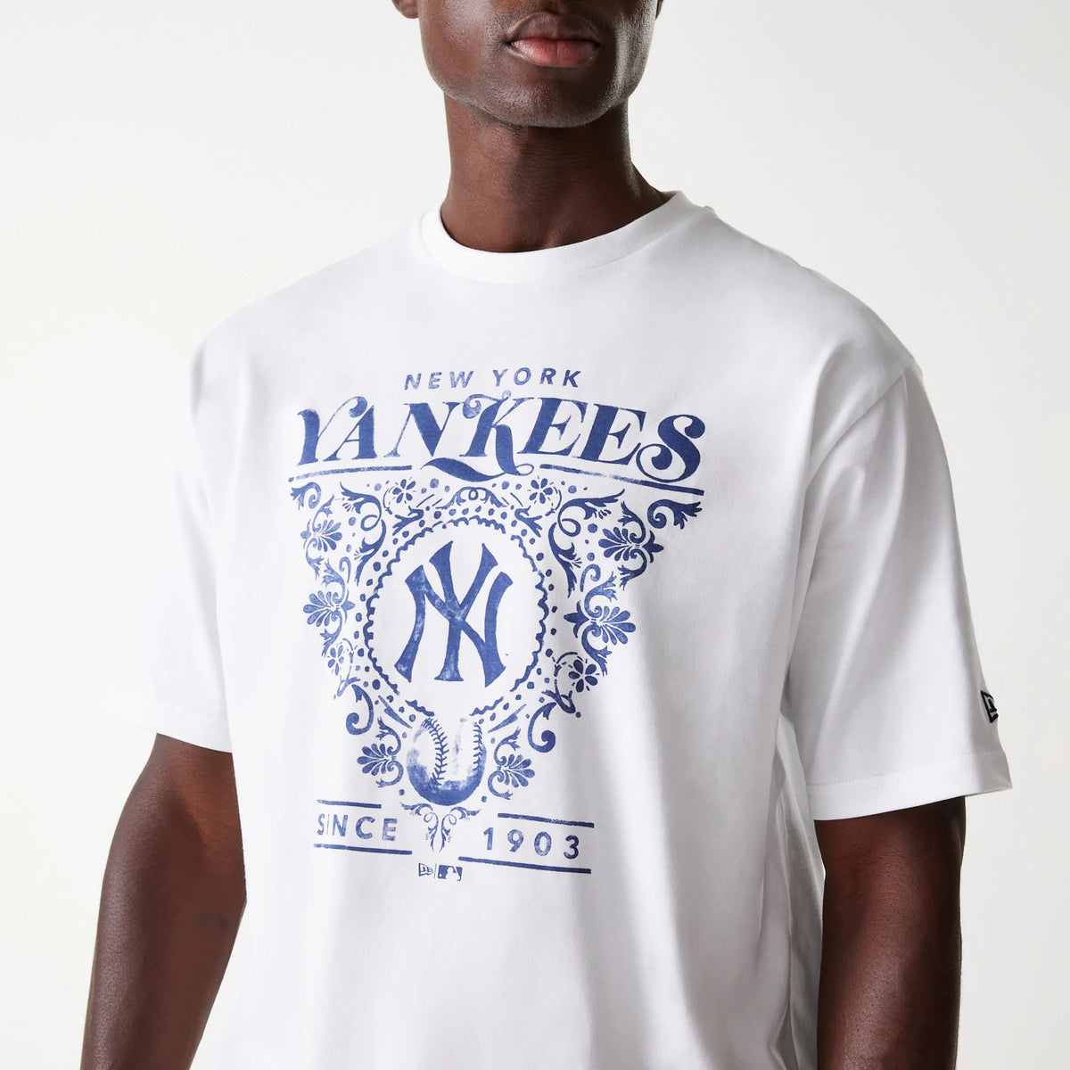 New Era New York Yankees MLB Floral Graphic White Oversized T-Shirt, front view showing a large blue floral graphic design with New York Yankees text across the chest and a debossed New Era logo on the sleeve.