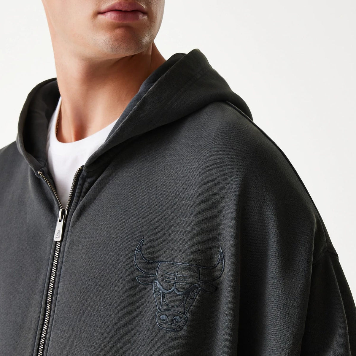 New Era Chicago Bulls NBA Washed Grey Full Zip Hoodie, on-model view showing the grey hoodie with raised Chicago Bulls logo on the left chest, a full zip closure down the front and a relaxed hood.