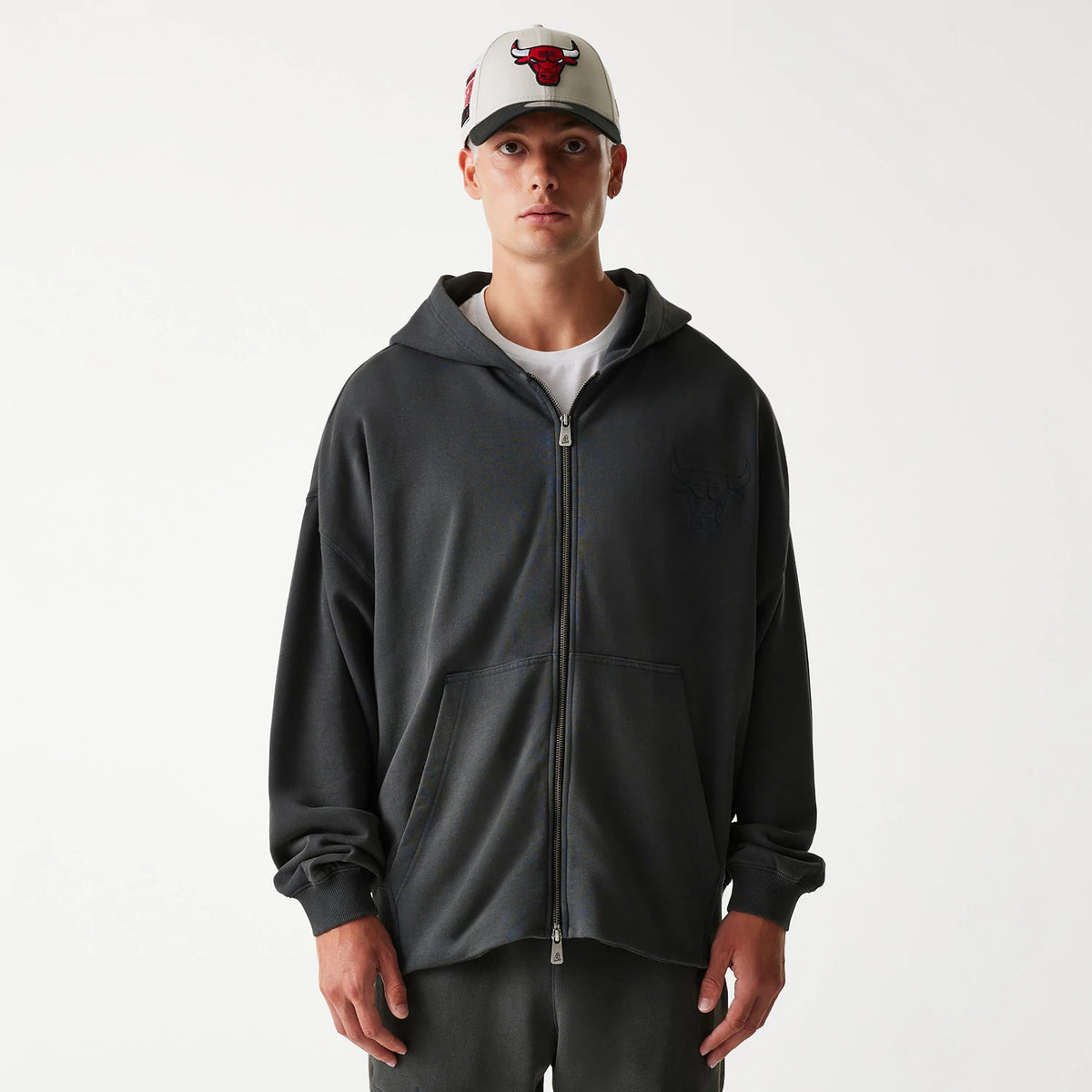 New Era Chicago Bulls NBA Washed Grey Full Zip Hoodie, front view showing the grey hoodie with a full zip closure, a debossed Bulls logo on the left chest, and a white cap with a raised Bulls logo on-model.