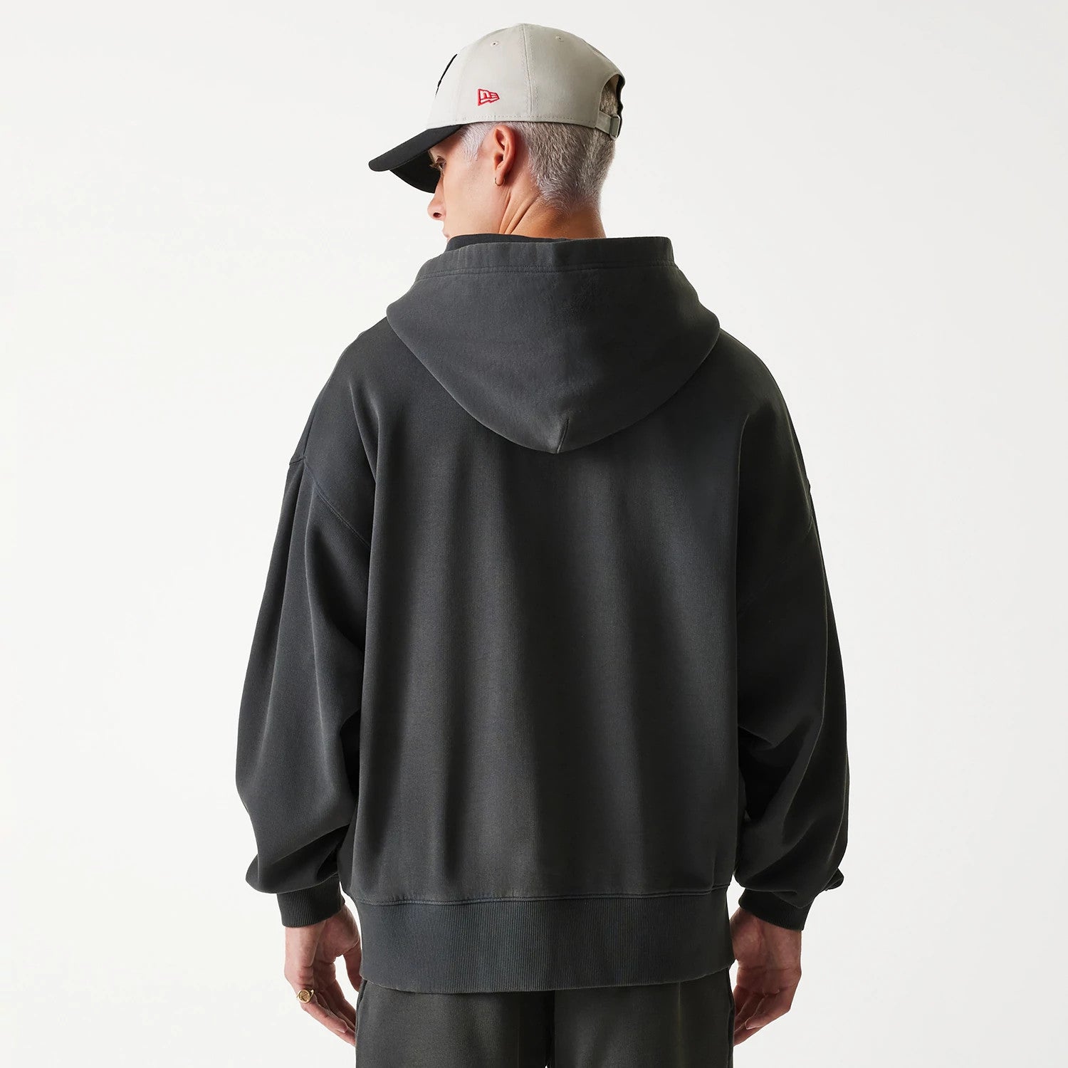 New Era Chicago Bulls NBA Washed Grey Full Zip Hoodie, on-model view showing the relaxed fit and hood from the back, paired with a grey cap featuring a raised red New Era logo on the side.