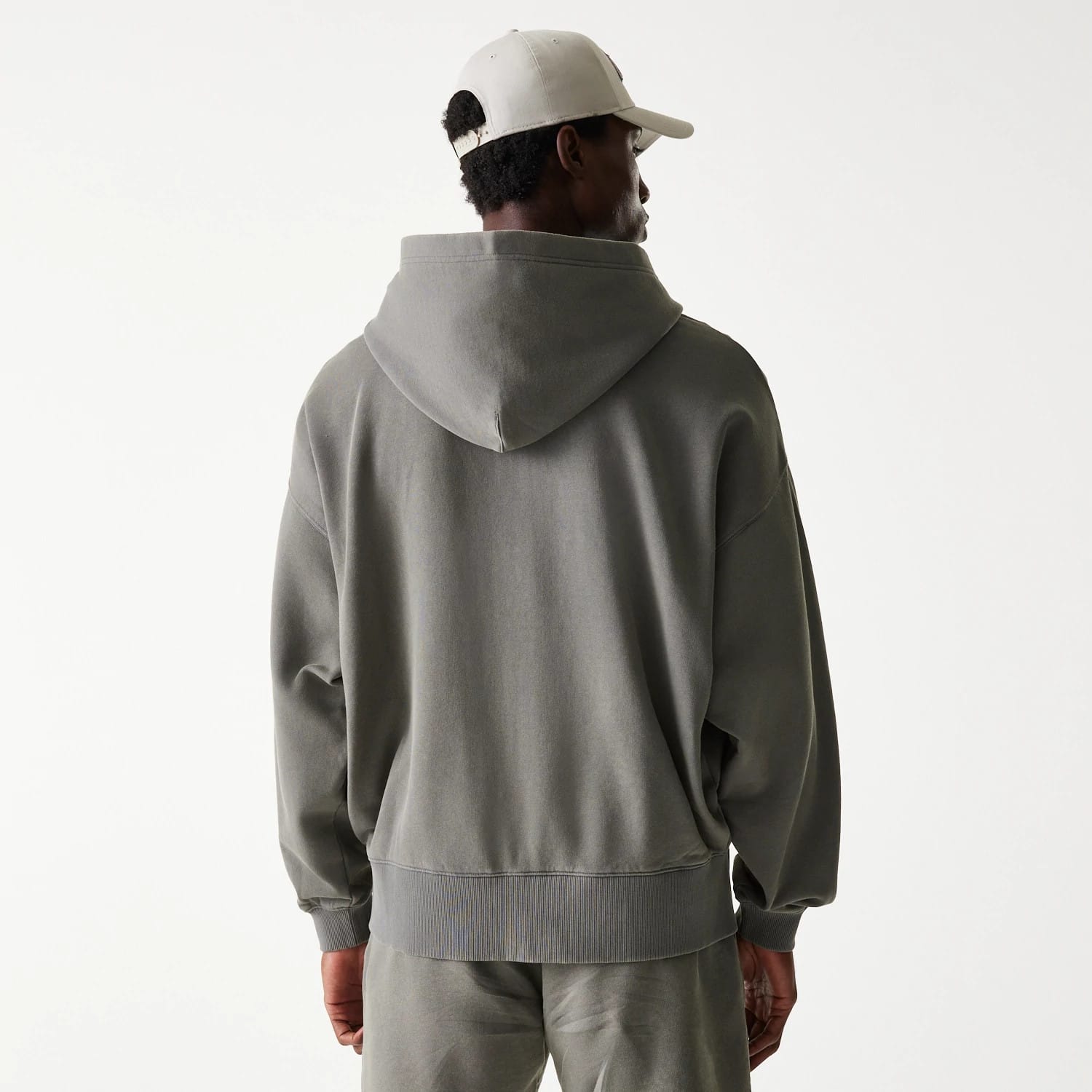 New Era LA Lakers NBA Washed Grey Full Zip Hoodie, rear view showing the relaxed fit grey hoodie with a roomy hood draping down the back, ribbed cuffs and hem, and a white debossed New Era logo on a cream cap worn by the model.
