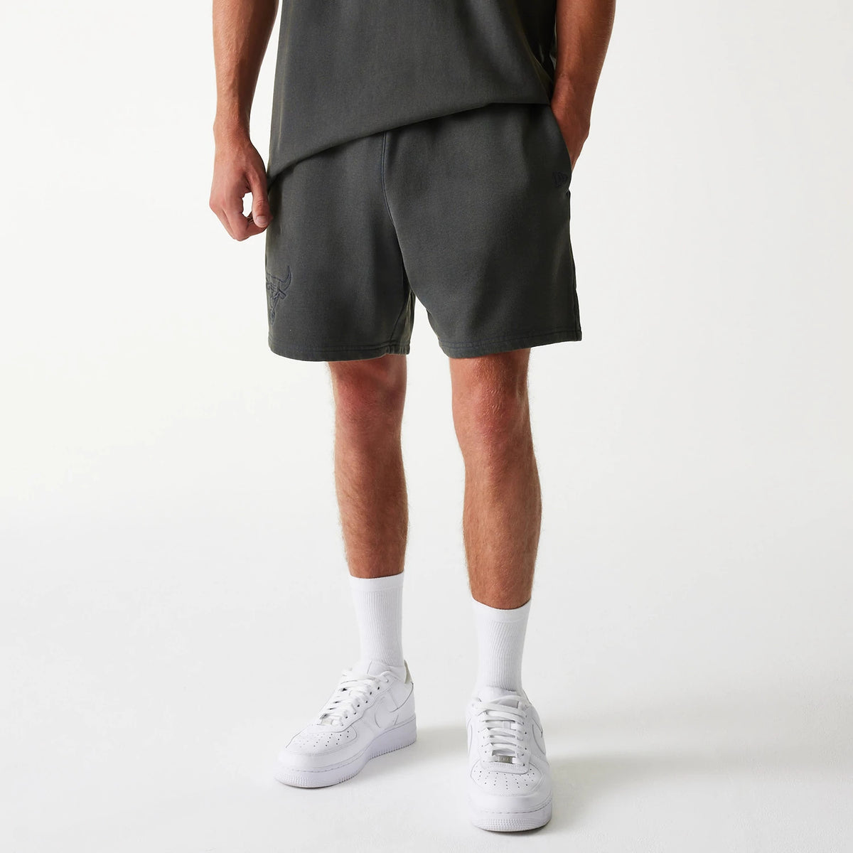 New Era Chicago Bulls NBA Washed Grey Shorts, front view showing the washed grey fabric with a raised Chicago Bulls logo on the left leg and a raised New Era logo on the right leg near the side seam.