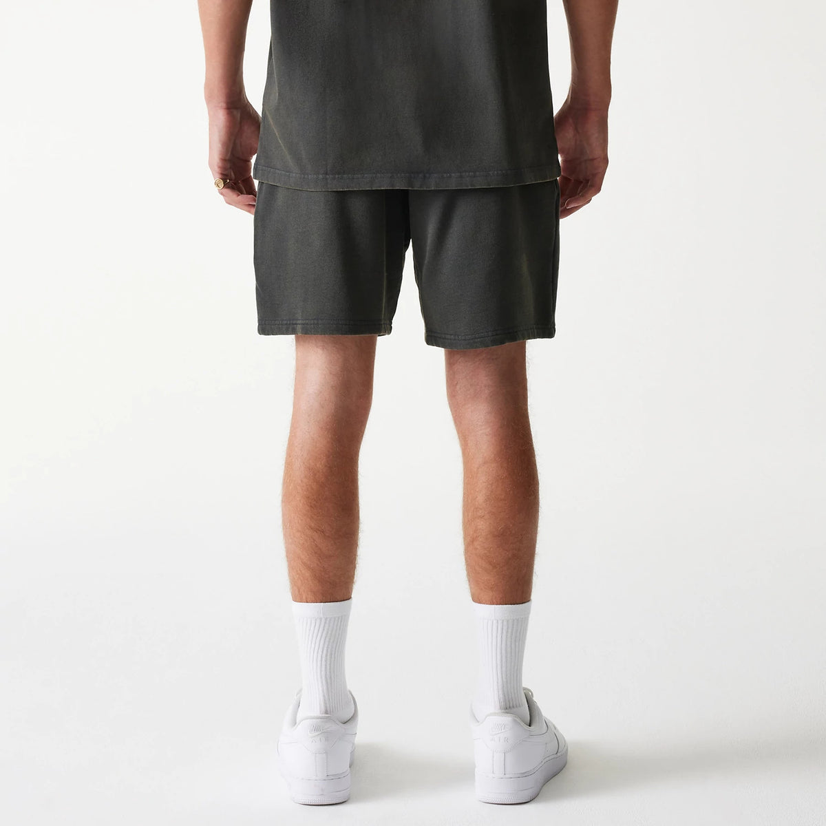 New Era Chicago Bulls NBA Washed Grey Shorts, rear view showing the faded grey fabric falling just above the knees, straight hem, and a loose fit around the legs, with the waistband slightly gathered at the back.