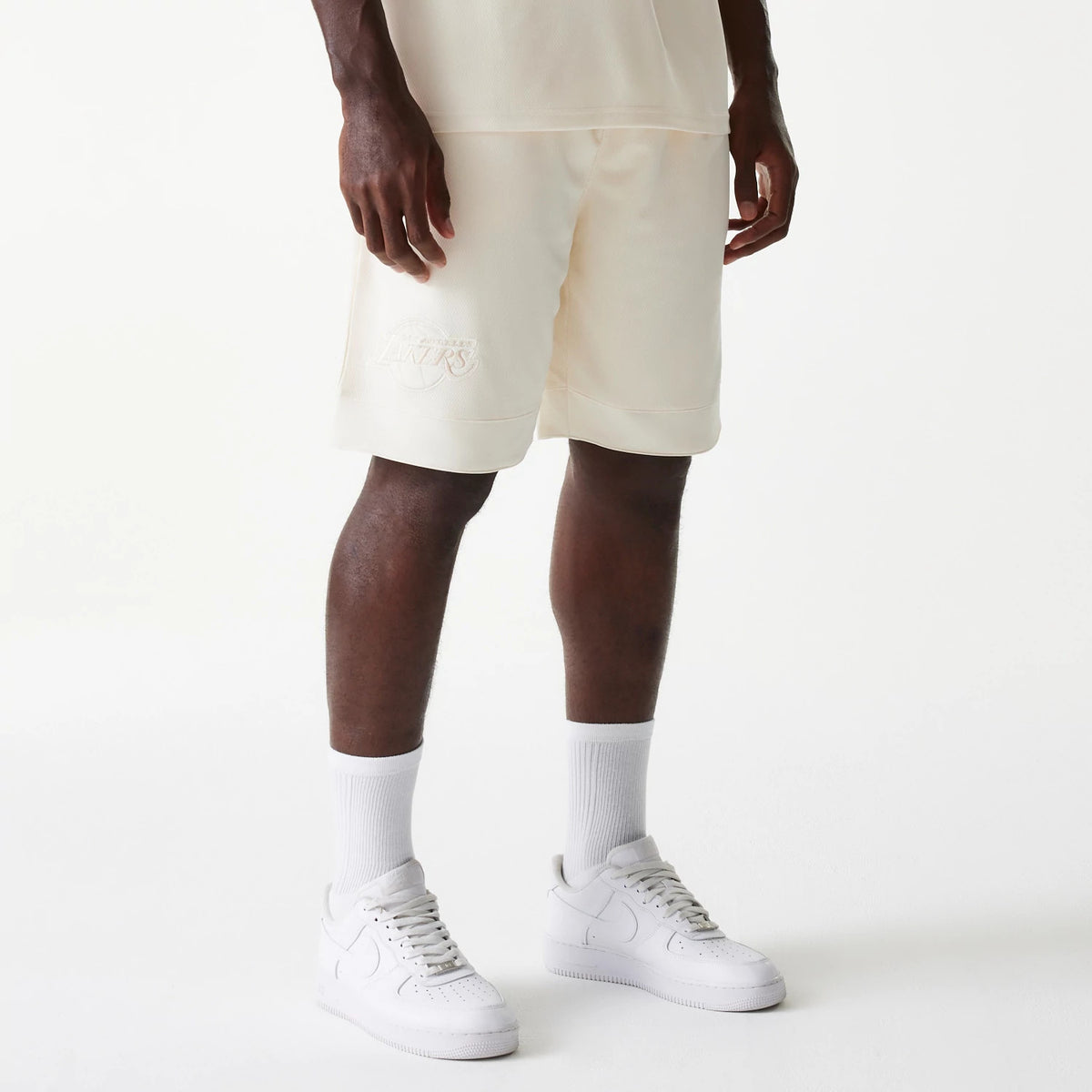 New Era LA Lakers NBA Tonal Open White Mesh Shorts, front view showing white shorts with a raised Lakers logo on the lower left leg and a straight hem falling just above the knee.