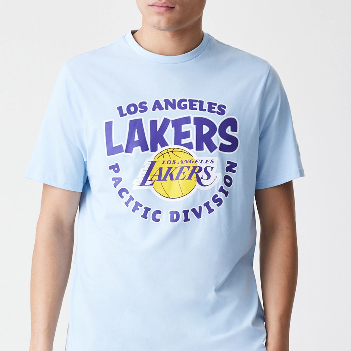 New Era LA Lakers NBA Bubble Wordmark Pastel Blue T-Shirt, front view showing a large printed Los Angeles Lakers logo featuring purple text and a yellow basketball on the chest of a light blue short-sleeved shirt worn by a model.