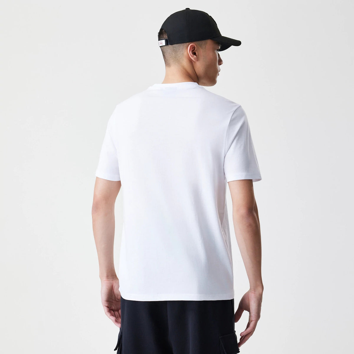 New Era Chicago Bulls NBA Stack Wordmark White T-Shirt, on-model rear view showing a plain white back with short sleeves, paired with a black cap that has a debossed logo on the side of the headwear.