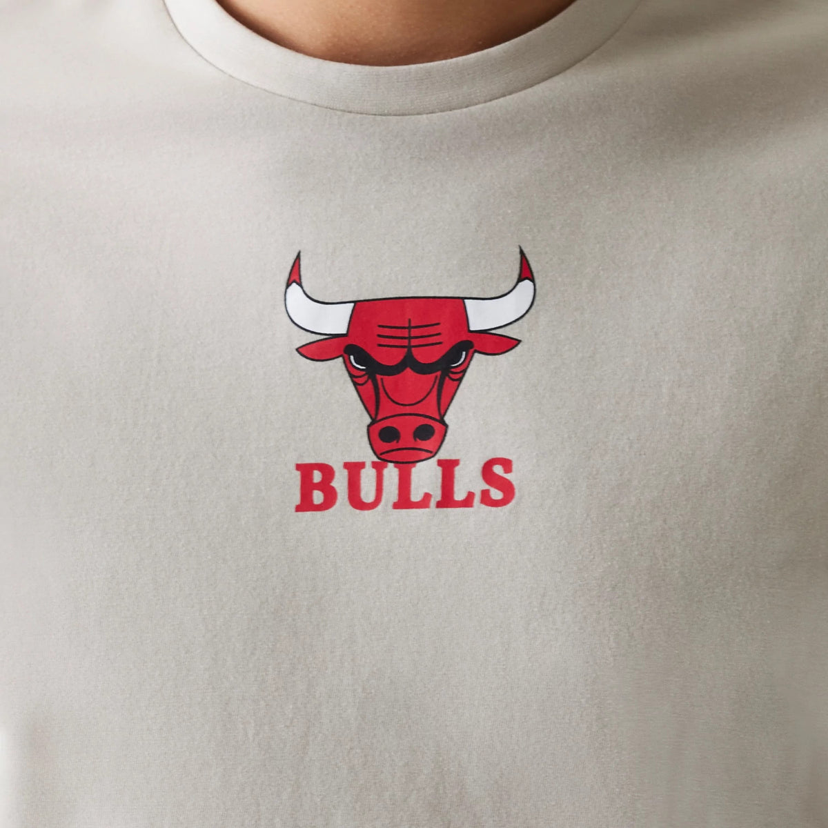 New Era Chicago Bulls NBA Logo Cream T-Shirt, front view showing a prominent red Bulls logo and text printed on the centre of the cream fabric, with a round neckline.