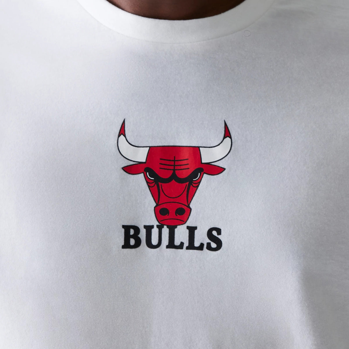 New Era Chicago Bulls NBA Logo White T-Shirt, front view showing a bold red and black Bulls logo with horns centred on the chest, below the word BULLS in black text on the smooth white fabric.