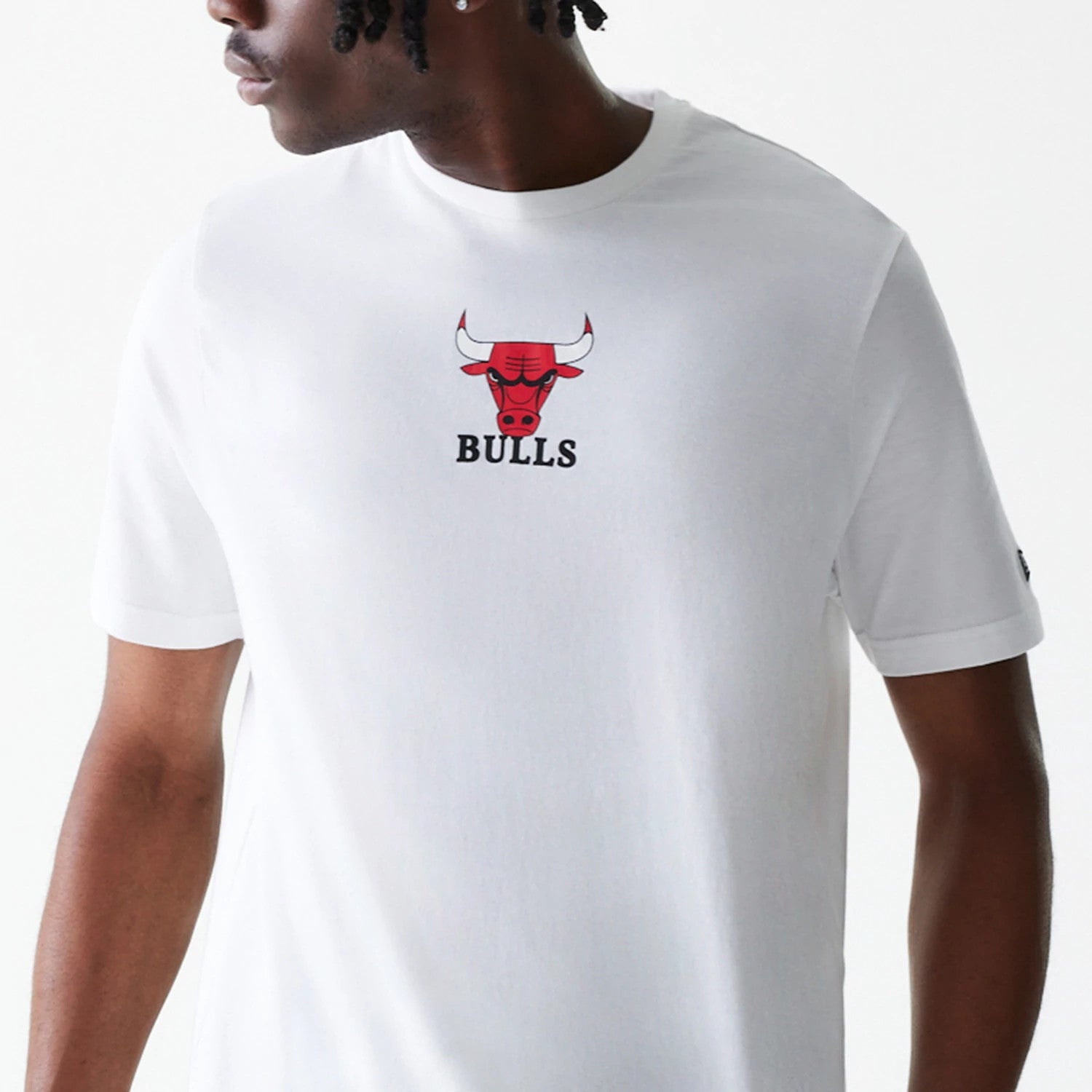 New Era Chicago Bulls NBA Logo White T-Shirt, front view showing the central red and black Bulls logo with debossed features, the word Bulls beneath it, on a plain white fabric with short sleeves.