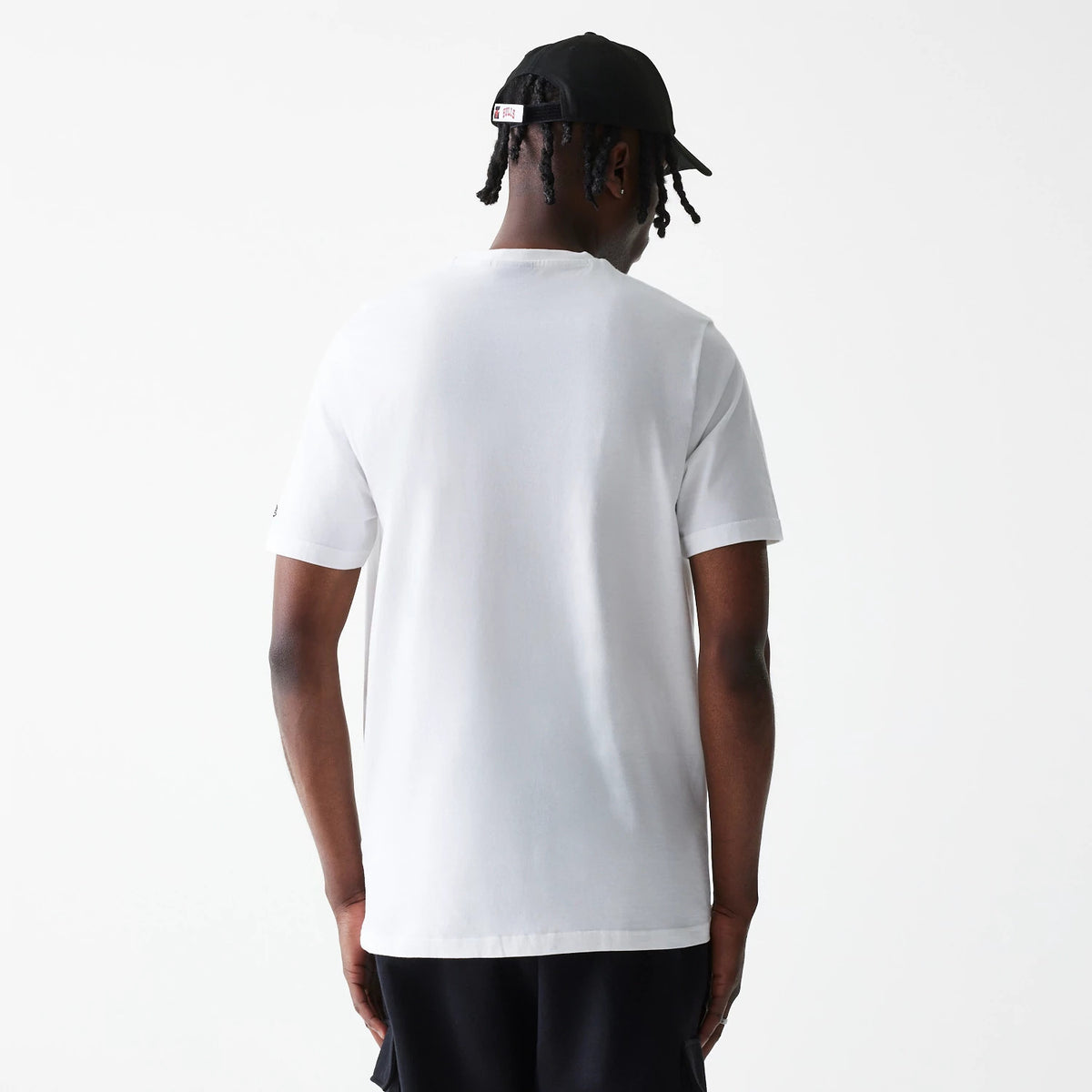 New Era Chicago Bulls NBA Logo White T-Shirt, on-model view showing the back of a plain white T-shirt with short sleeves worn by a person, with the T-shirt reaching down to the hip and a small black logo on the left sleeve.
