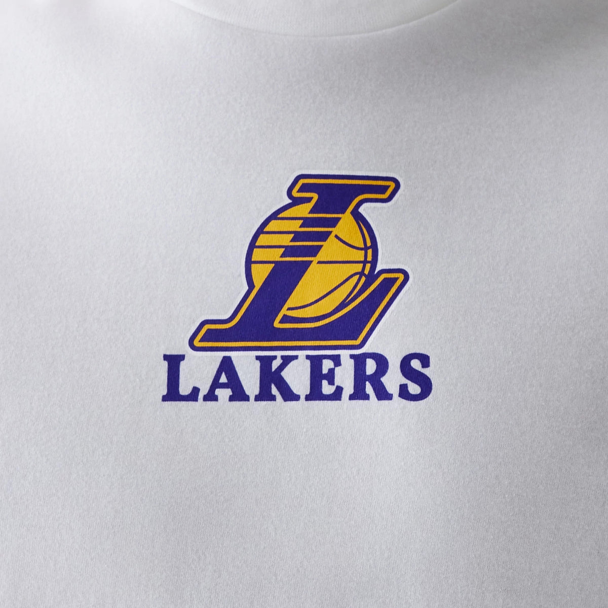 New Era LA Lakers NBA Logo White T-Shirt, front view showing a large purple and yellow Lakers logo printed on the centre of the white fabric, with the letter 'L' and basketball graphic above the word 'LAKERS' in bold purple letters.
