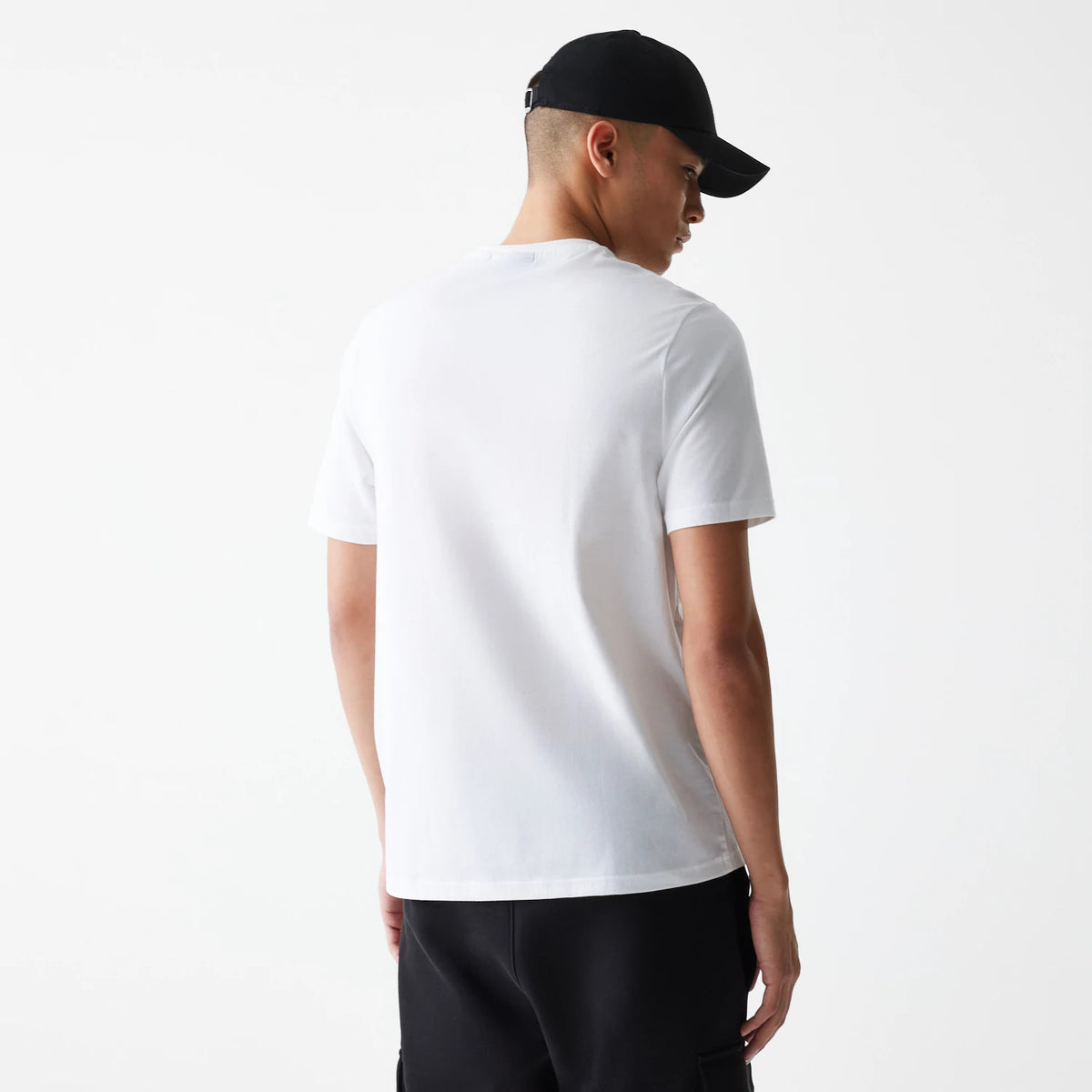 New Era LA Lakers NBA Logo White T-Shirt, back view showing the plain white fabric with short sleeves, a crew neckline, and a person wearing a black cap, highlighting the simplicity and classic style of the shirt.
