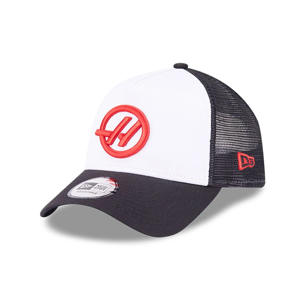 TGR Haas F1 Black New Era 9FORTY E-Frame Trucker Adjustable Cap, three-quarter view with a red embroidered logo on the white front panel, a black curved visor with 9FORTY size sticker, and red New Era flag logo on the left mesh side.