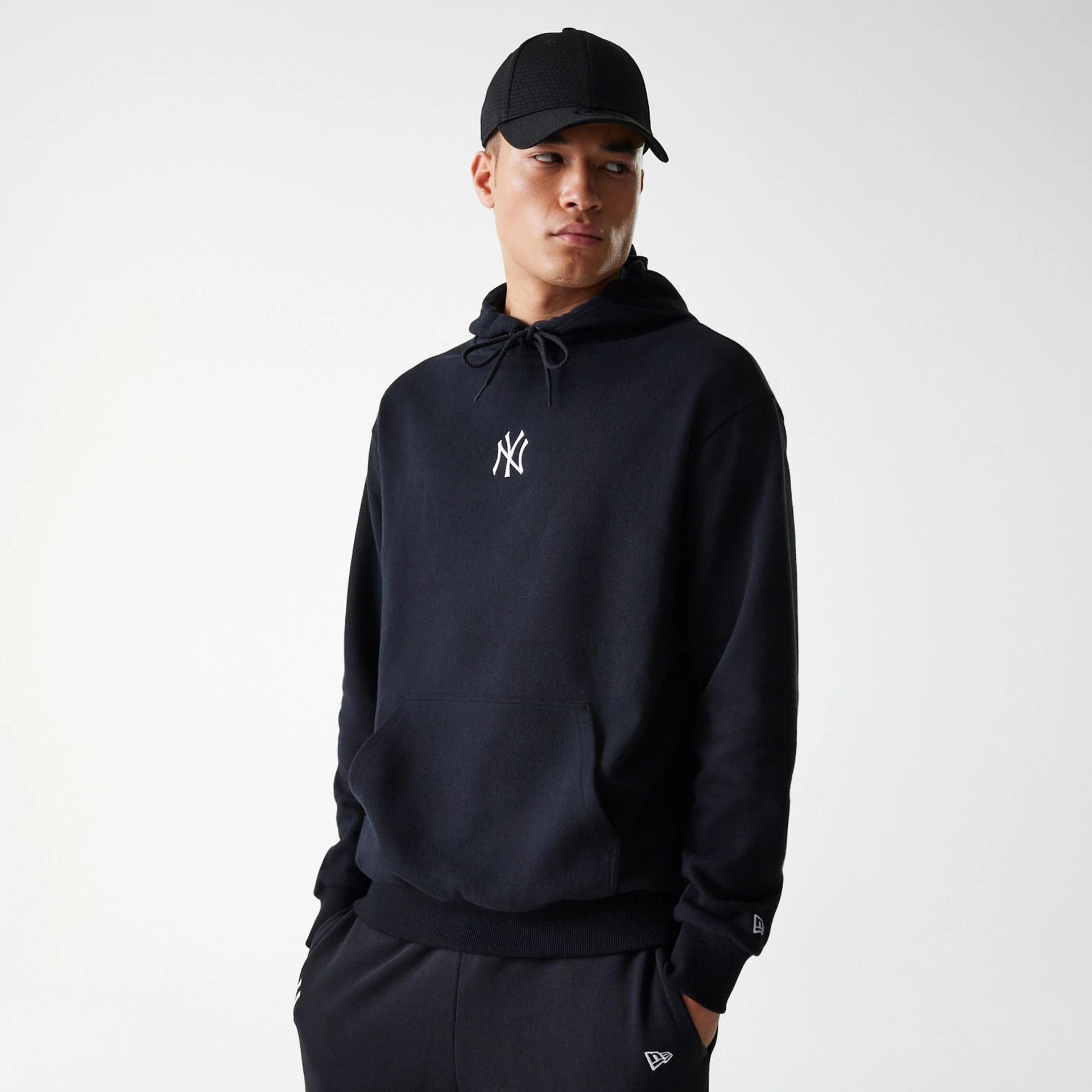 The Male model is wearing New York Yankees MLB League Essential Midi Black Oversized Pullover Hoodie 1
