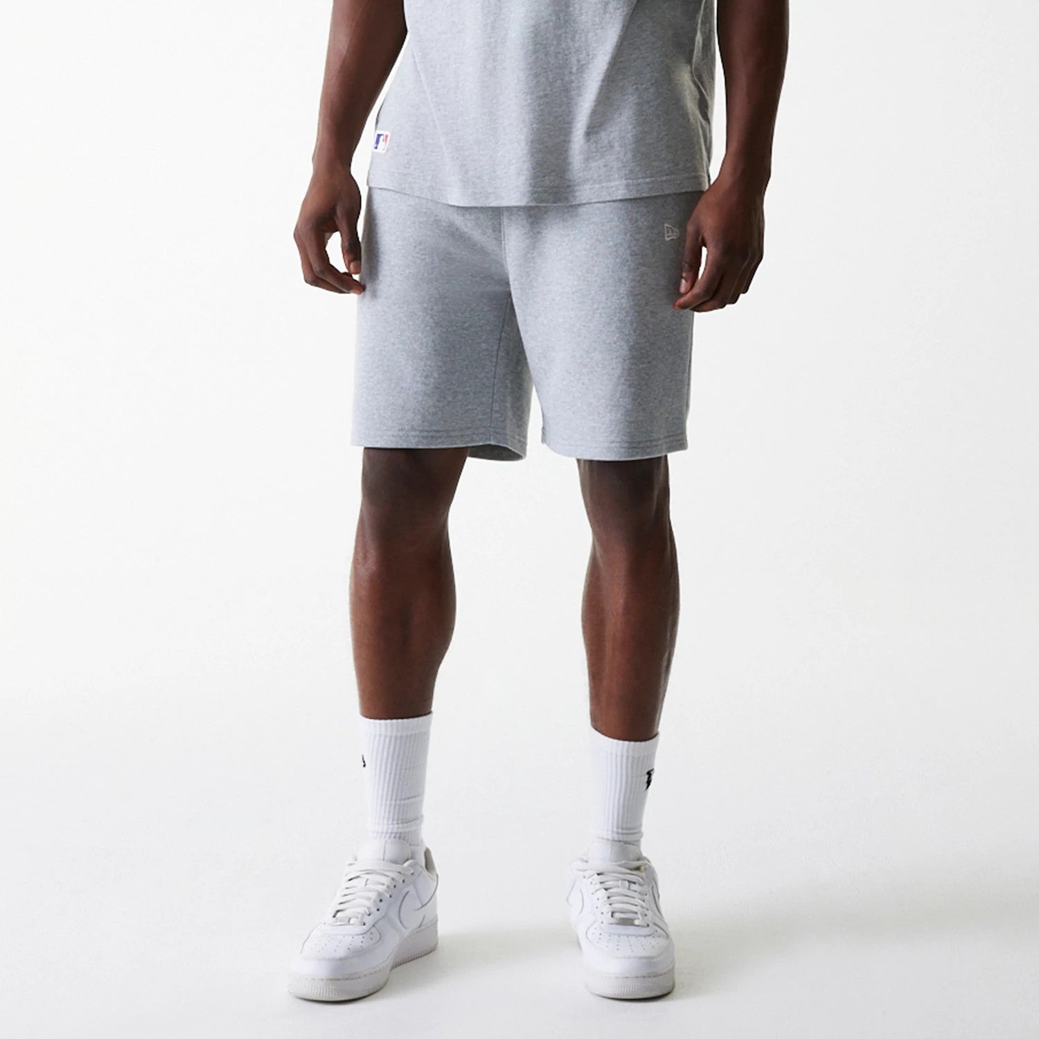New Era New York Yankees MLB League Essential French Terry Grey Shorts, front view showing the soft grey fabric with a raised New Era logo on the lower front, waistband fitting snugly at the waist, and relaxed fit ending slightly above the knees.