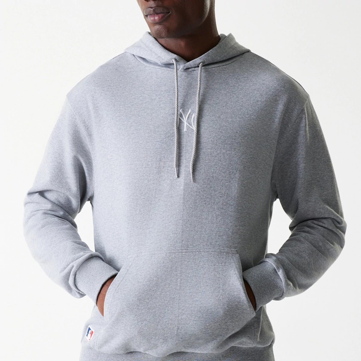 New Era New York Yankees MLB League Essential Midi French Terry Grey Oversized Pullover Hoodie, front view showing a light grey hoodie with a raised white Yankees logo on the chest, a drawstring hood, and a large front pocket.
