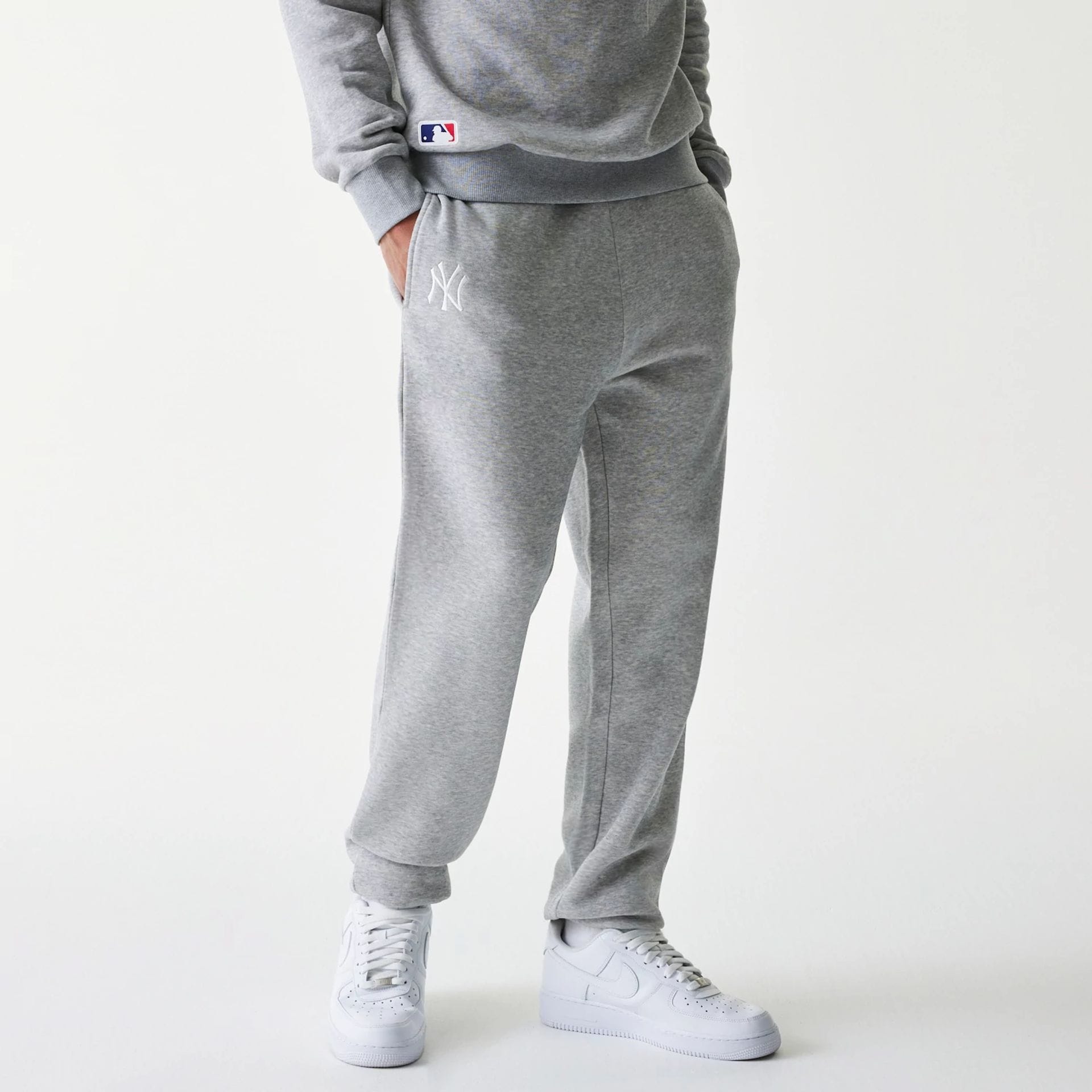 The Male model is wearing New York Yankees MLB League Essential Grey Joggers 1