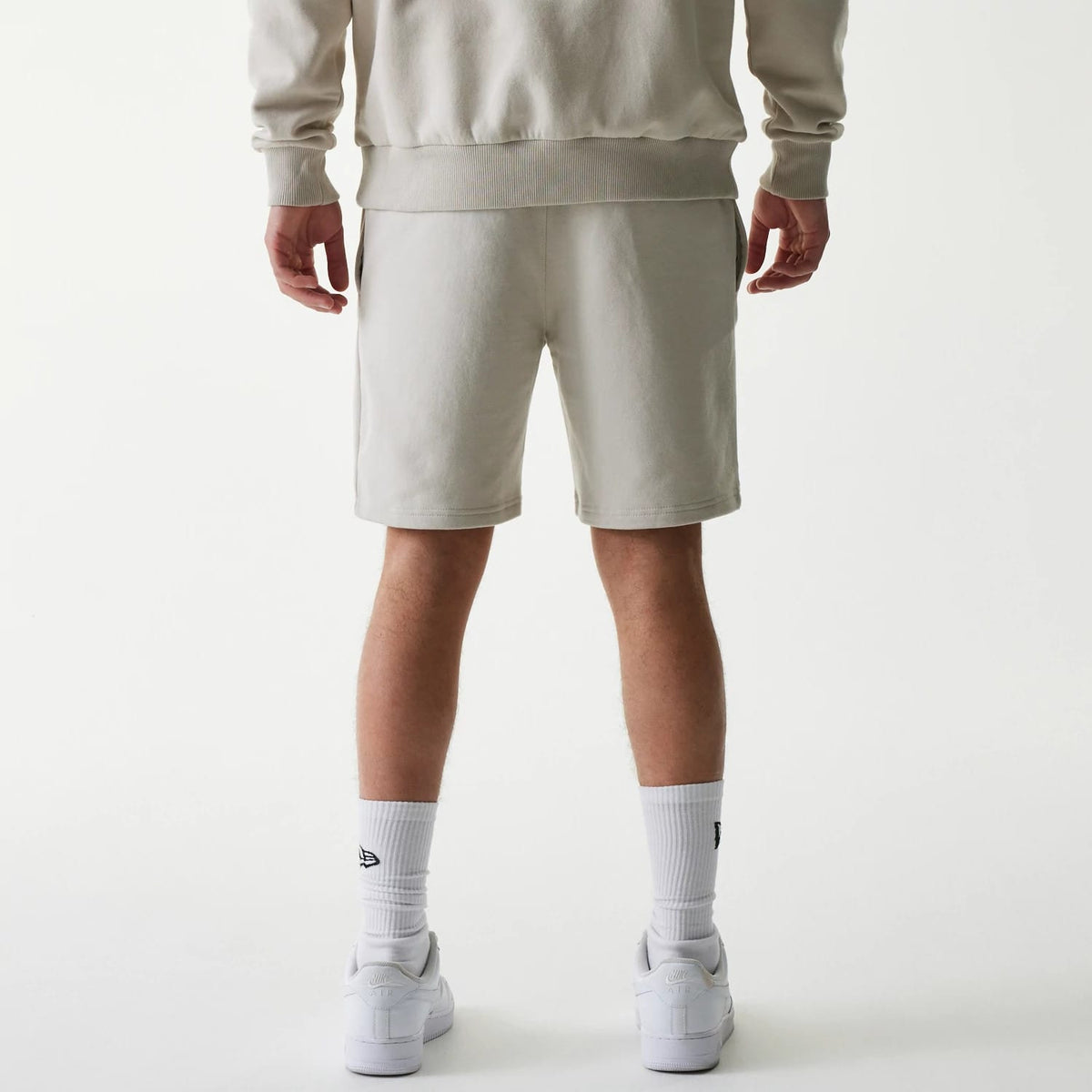 The Male model is wearing New York Yankees MLB League Essential Midi Cream Shorts 2