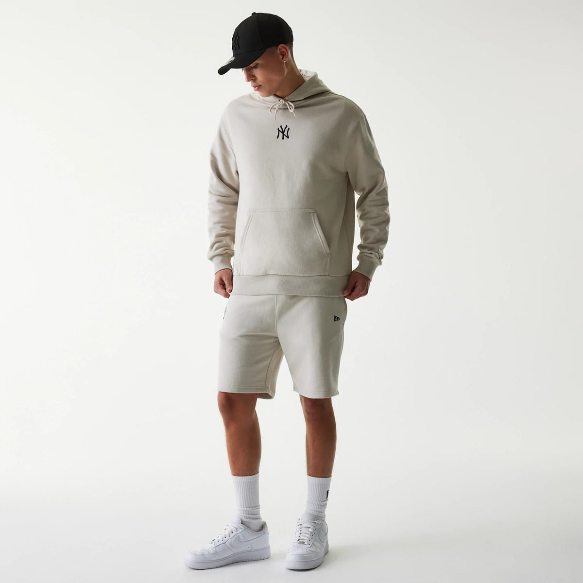 The Male model is wearing New York Yankees MLB League Essential Midi Cream Shorts 8