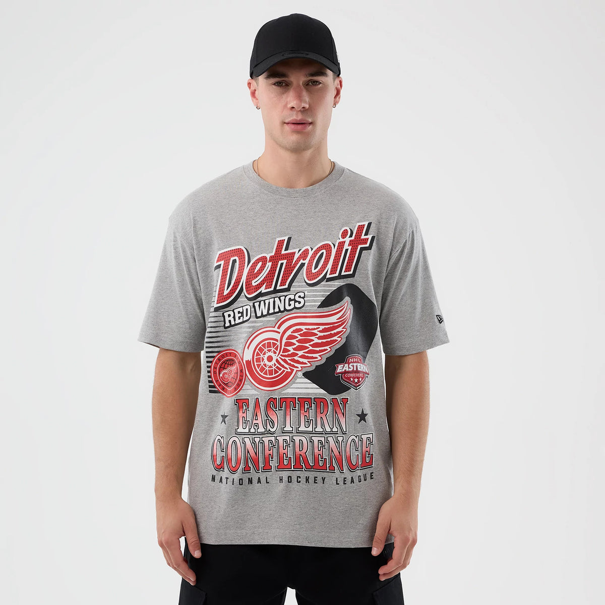 New Era Detroit Red Wings NHL Sport Classic Grey T-Shirt, on-model view showing the detailed print with Detroit Red Wings Eastern Conference and team emblem on the grey fabric, a small embroidered New Era logo on the sleeve.
