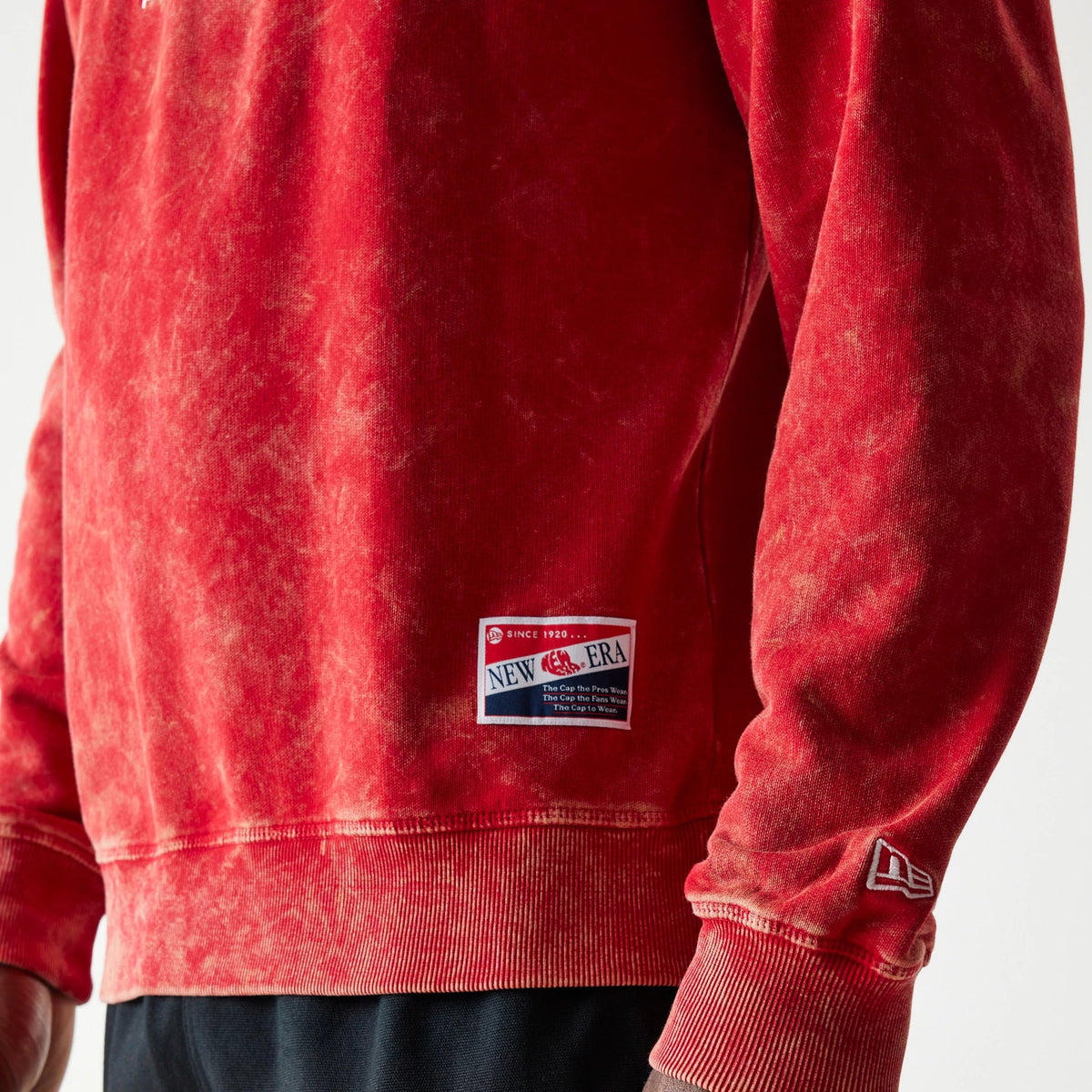 New Era Kansas City Chiefs NFL Throwback Red Crew Neck Sweater, side view with a vintage wash design showing a New Era patch above the waistband and the embroidered New Era flag logo on the sleeve.