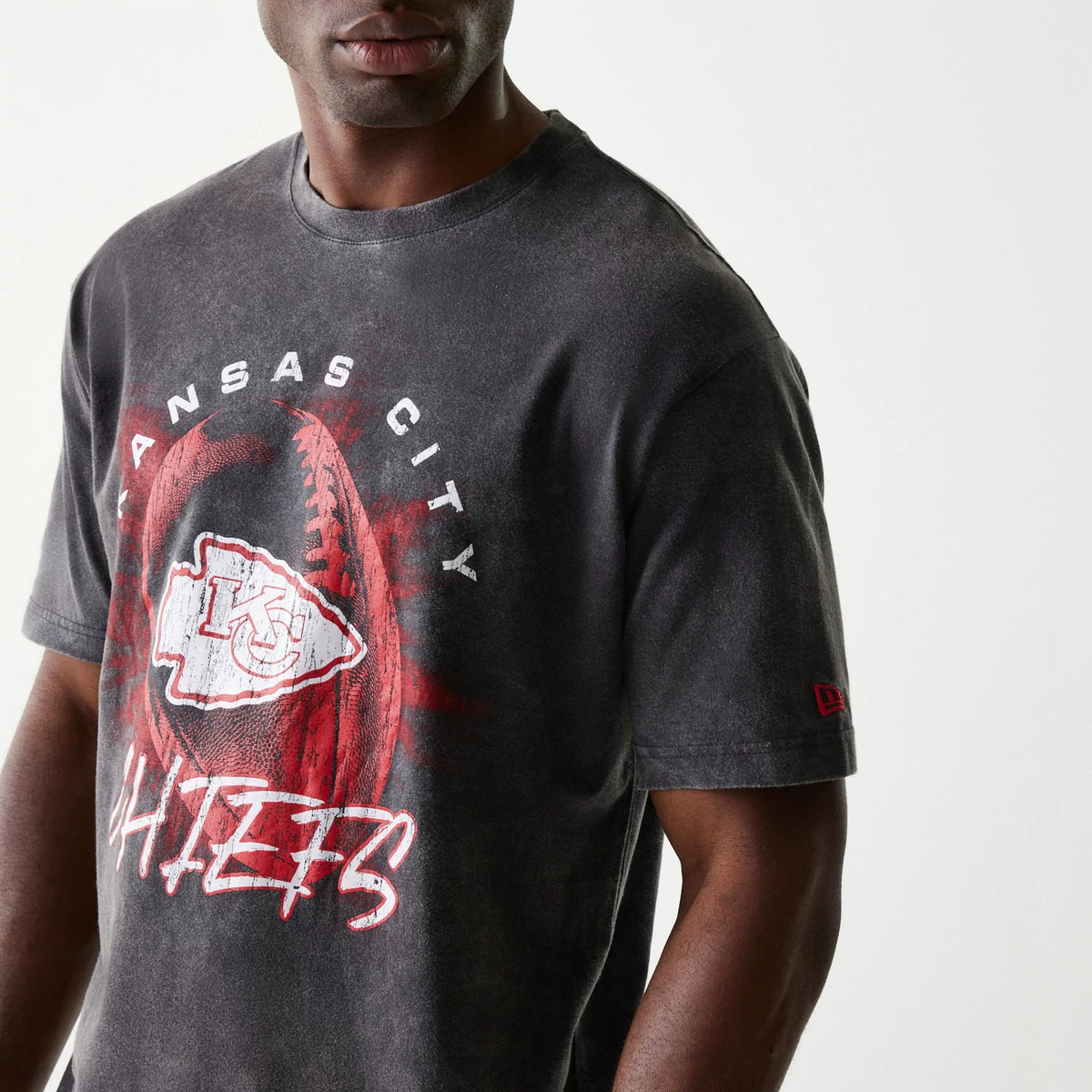New Era Kansas City Chiefs NFL Sport Night Black T-Shirt, front view showing the faded black fabric with a large red and white graphic of the Chiefs logo and text, and a small red embroidered New Era logo on the left sleeve.